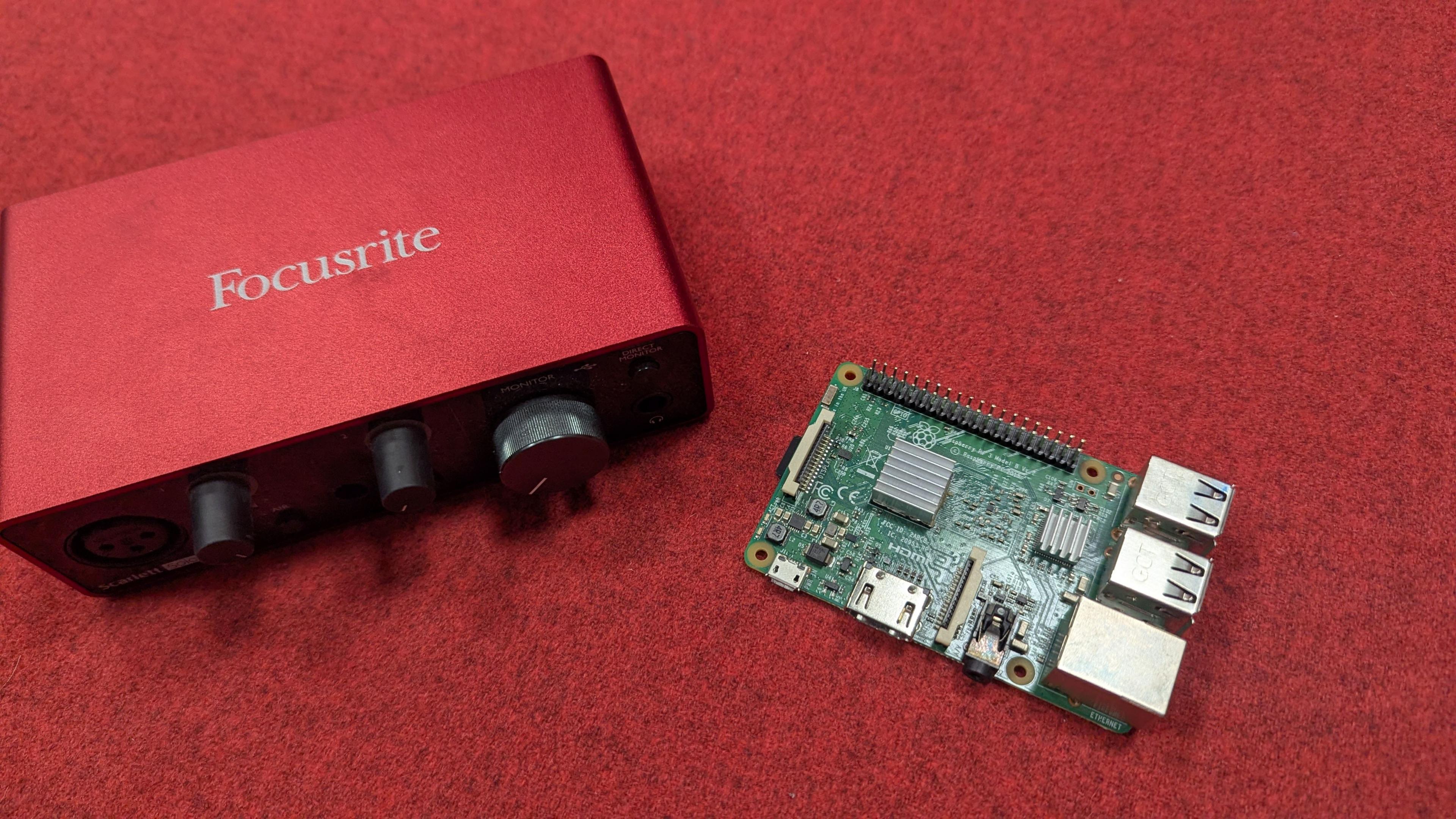 A red box with knobs and a raspberry pi circuit board which was the original prototype