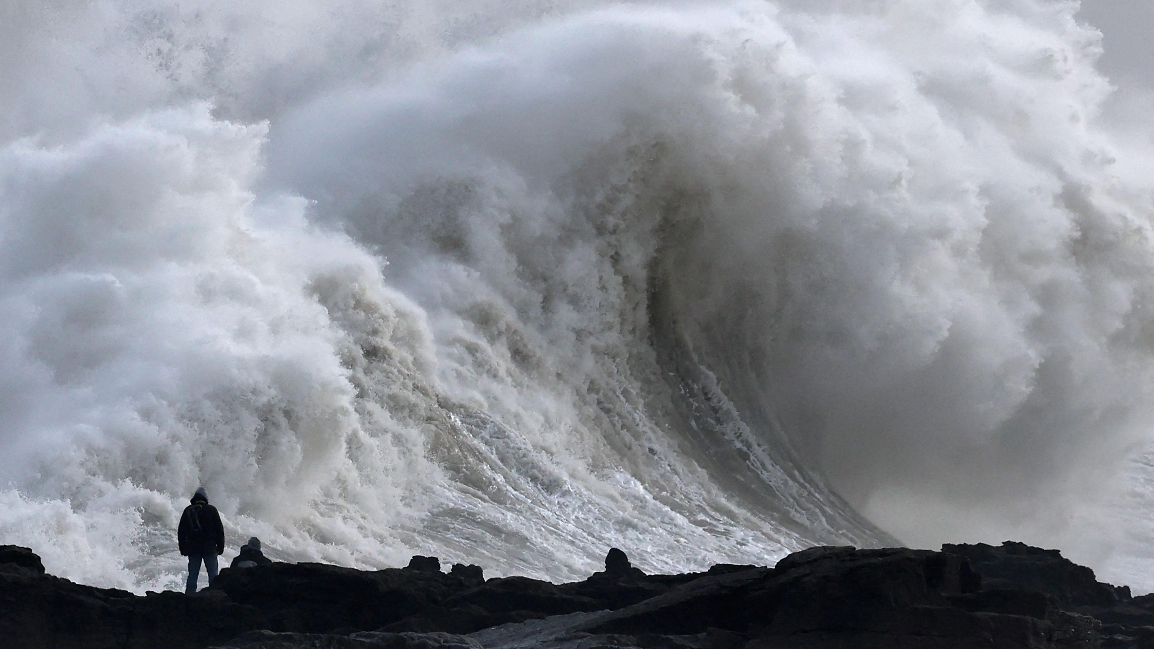 Silhouette of person viewing large waves as Storm Eowyn arrives in Porthcawl on 24 January