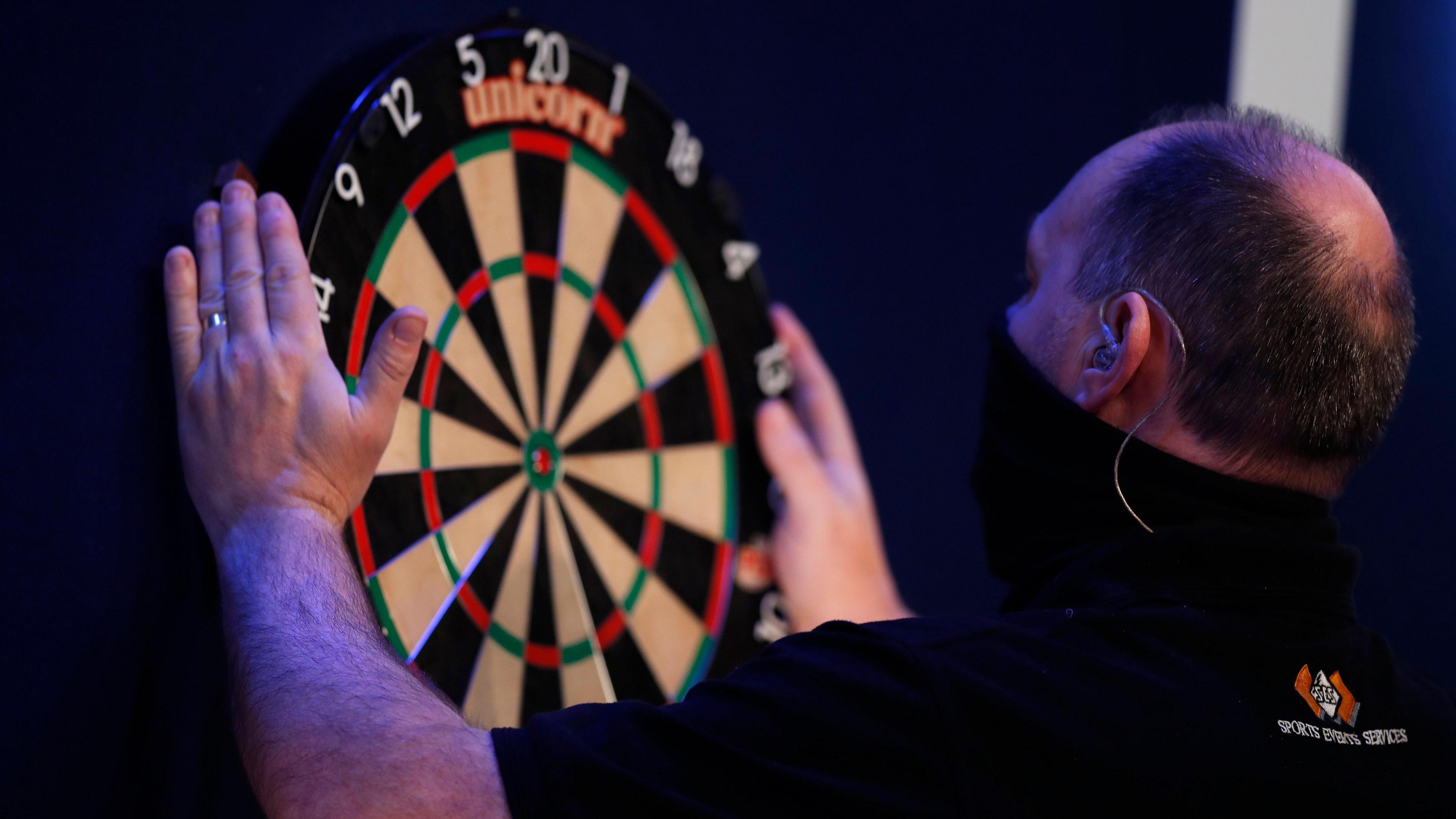 Member of staff replaces a darts board at the PDC World Darts Championship.