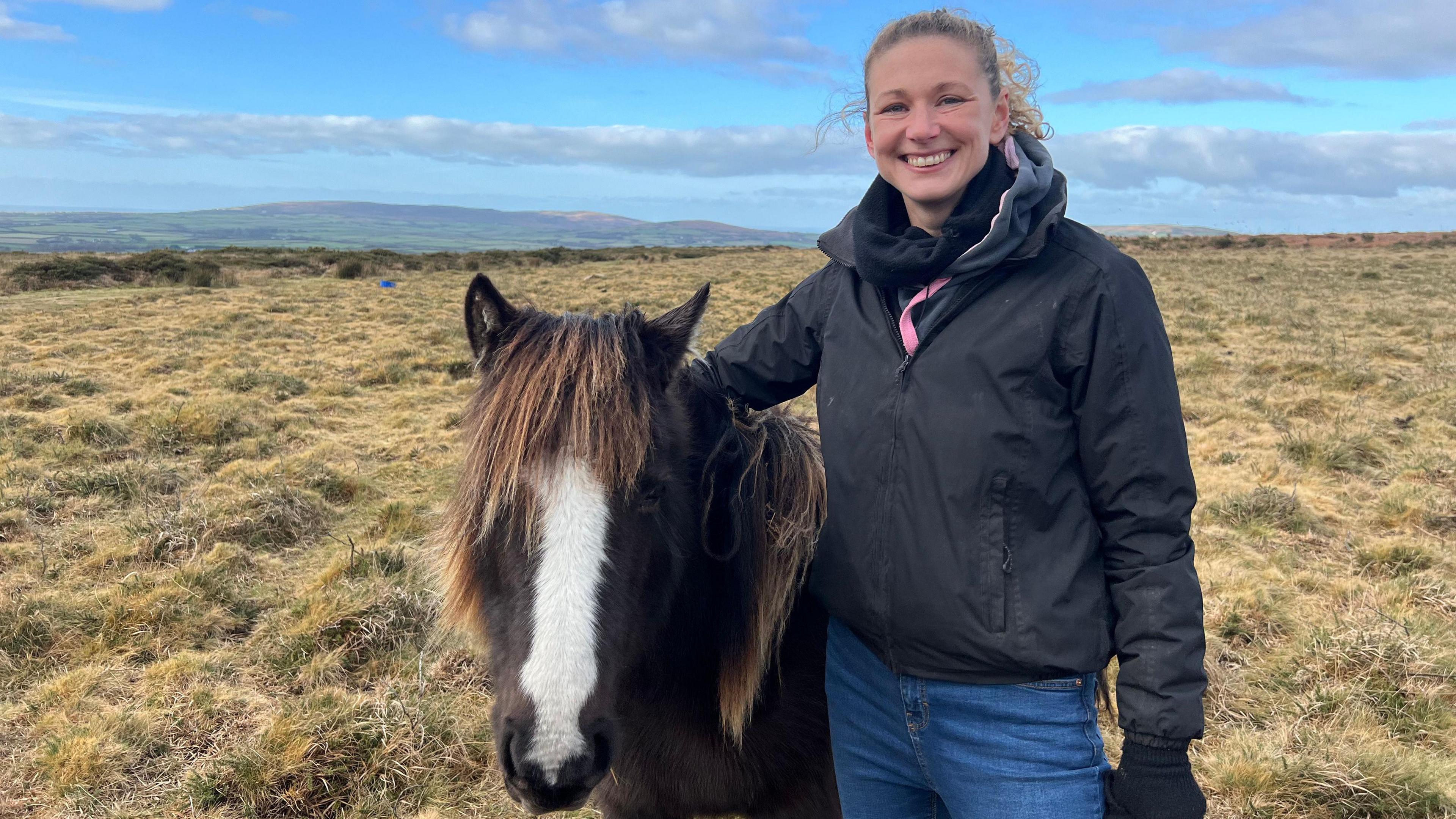 Woman with horse on moorland