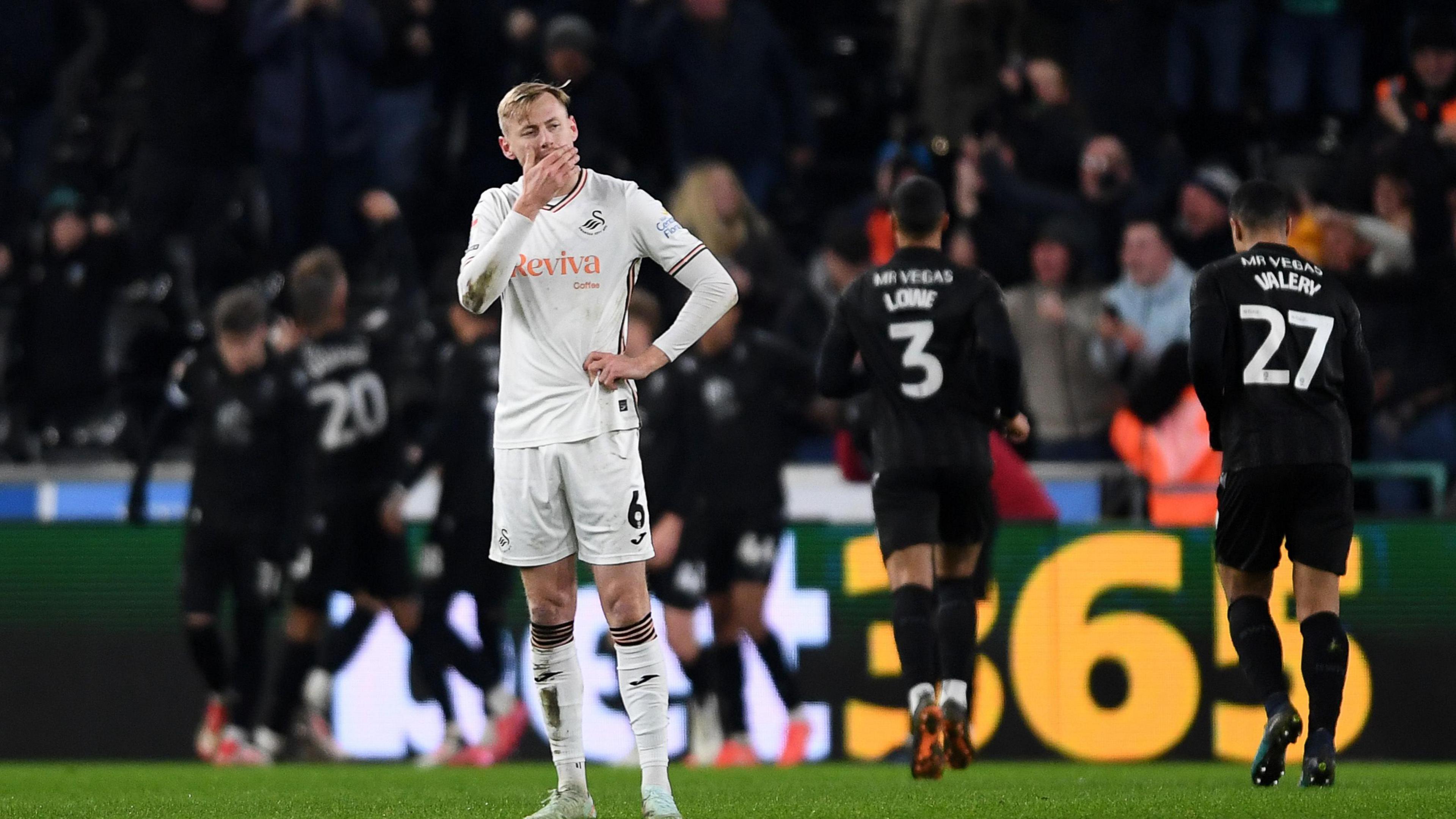 Harry Darling looks disappointed as Sheffield Wednesday players celebrate