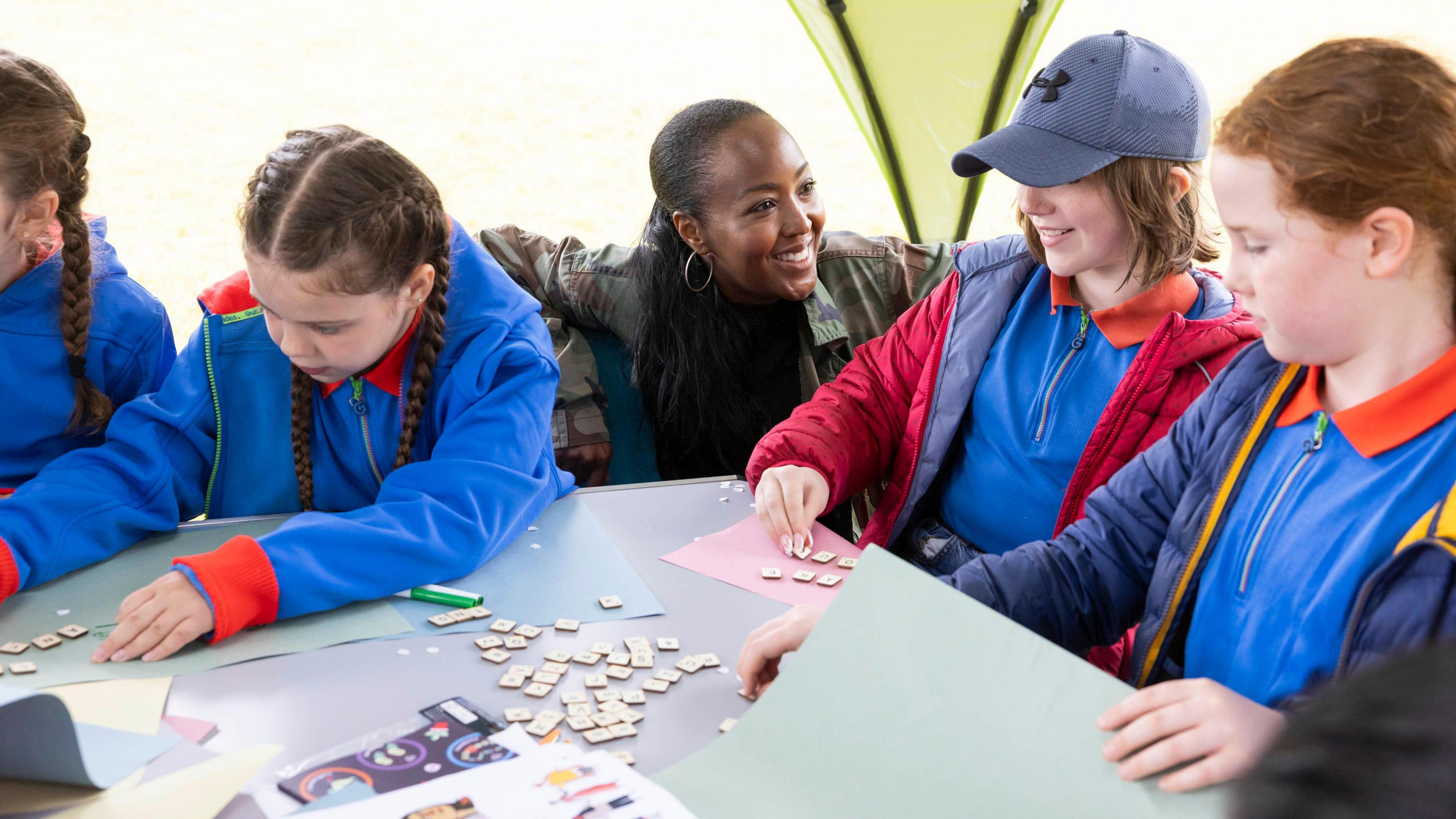 Girls doing an activity involving tiles and paper.