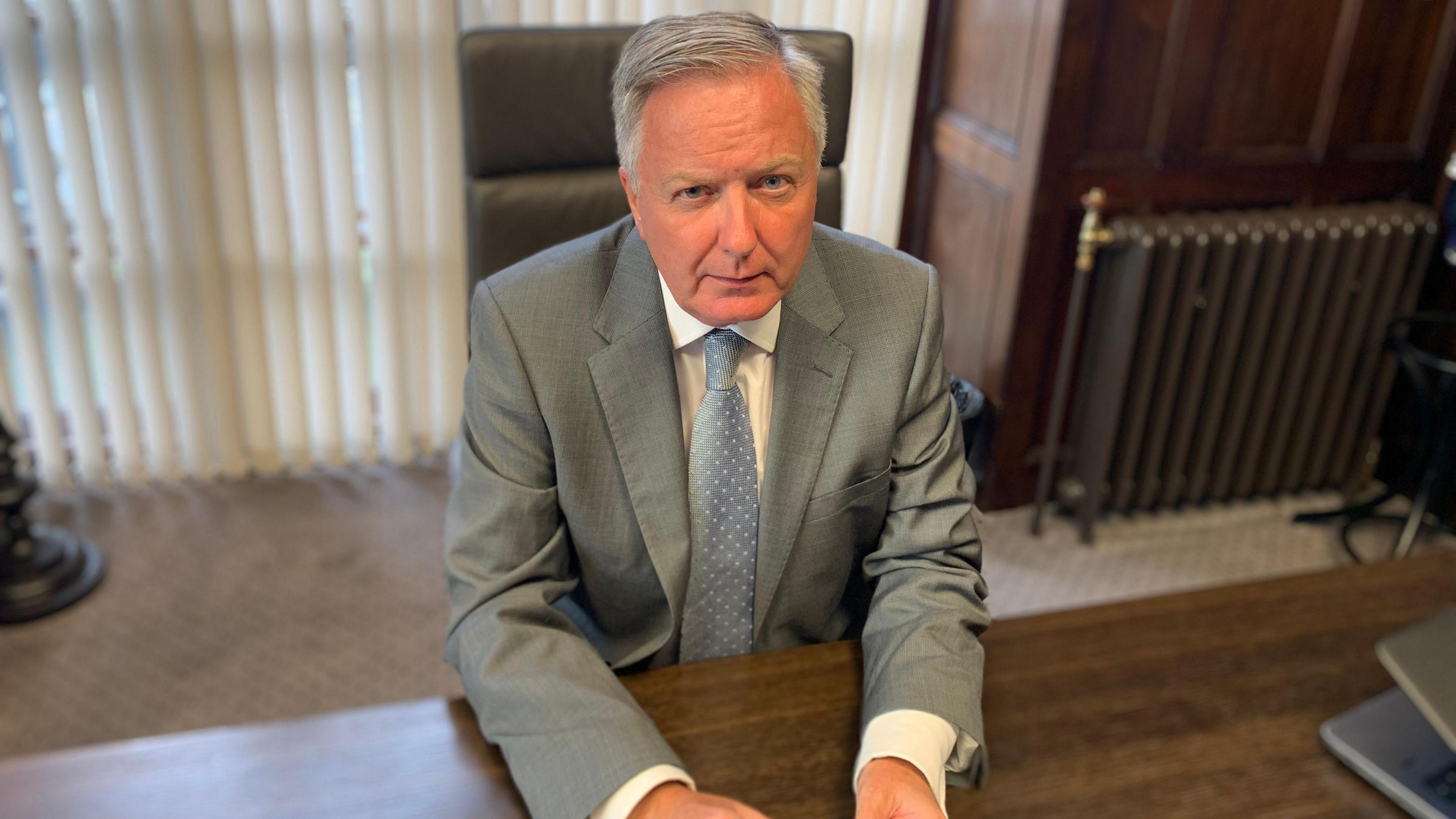 Iain Malcolm, sitting at a desk