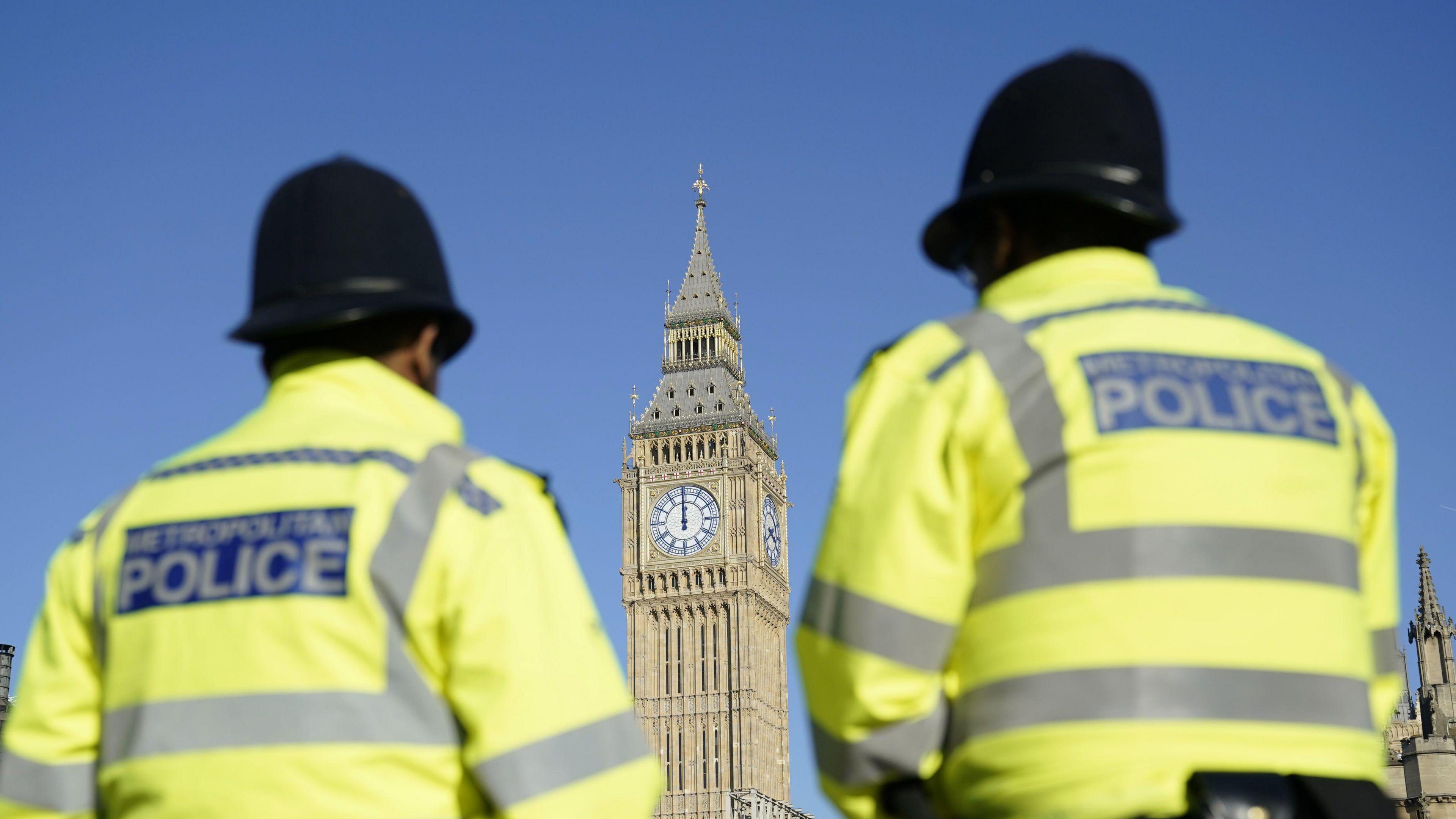 File image the Elizabeth Tower, part of the Palace of Westminster, seen between two out-of-focus uniformed Metropolitan Police officers in Parliament Square