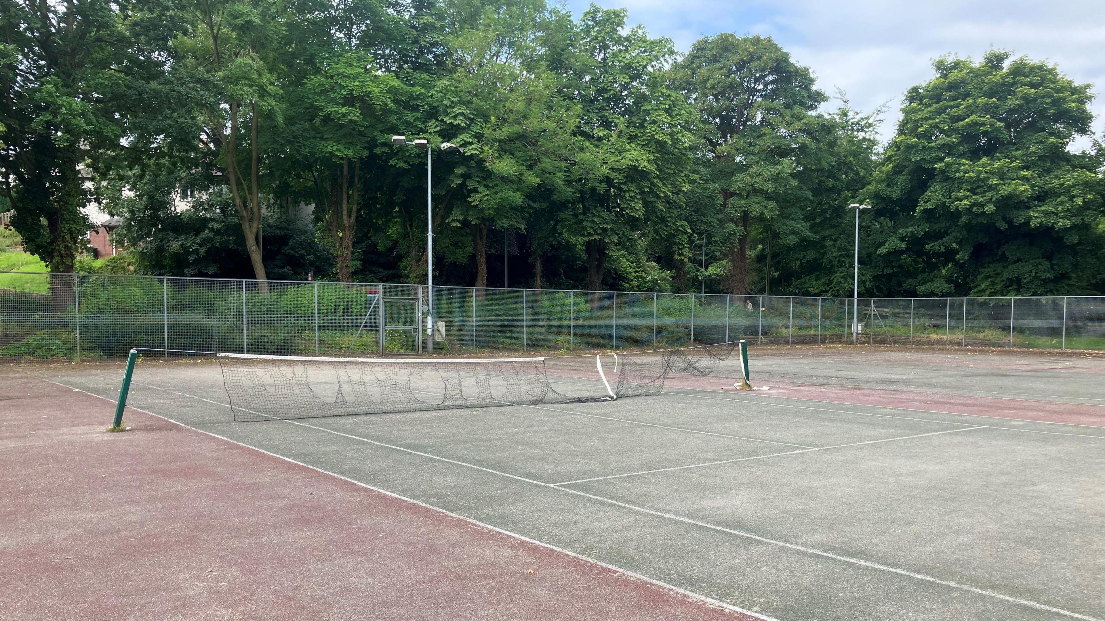 A tennis court with a ripped and broken net