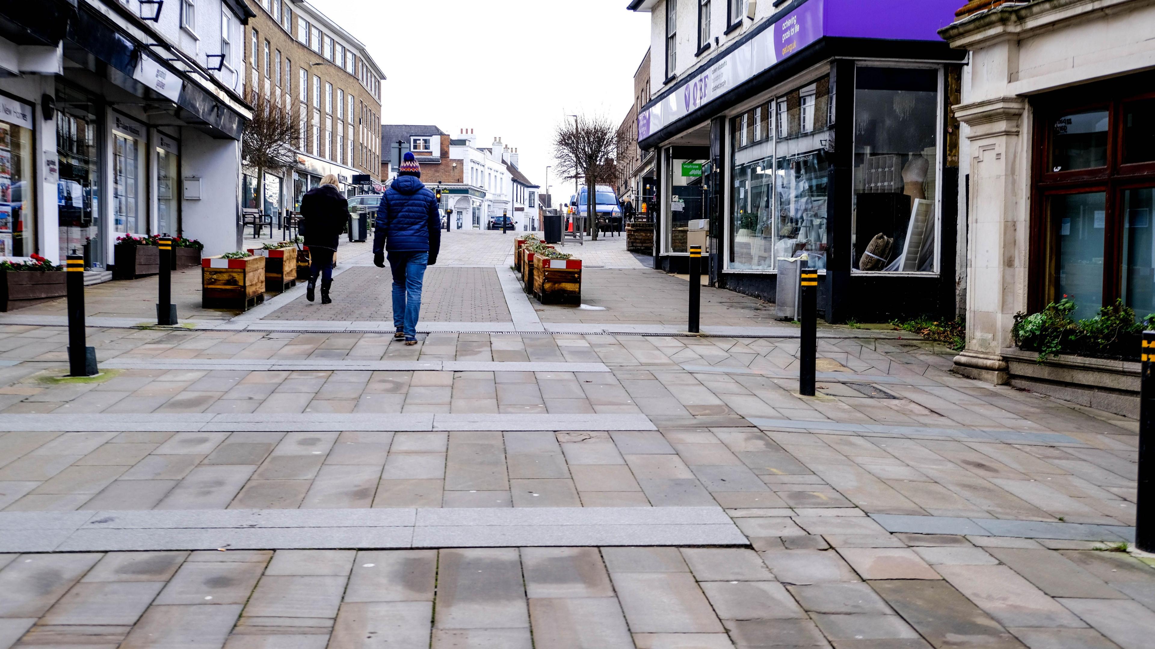 Two people walking down an otherwise deserted Leatherhead High Street in winter.