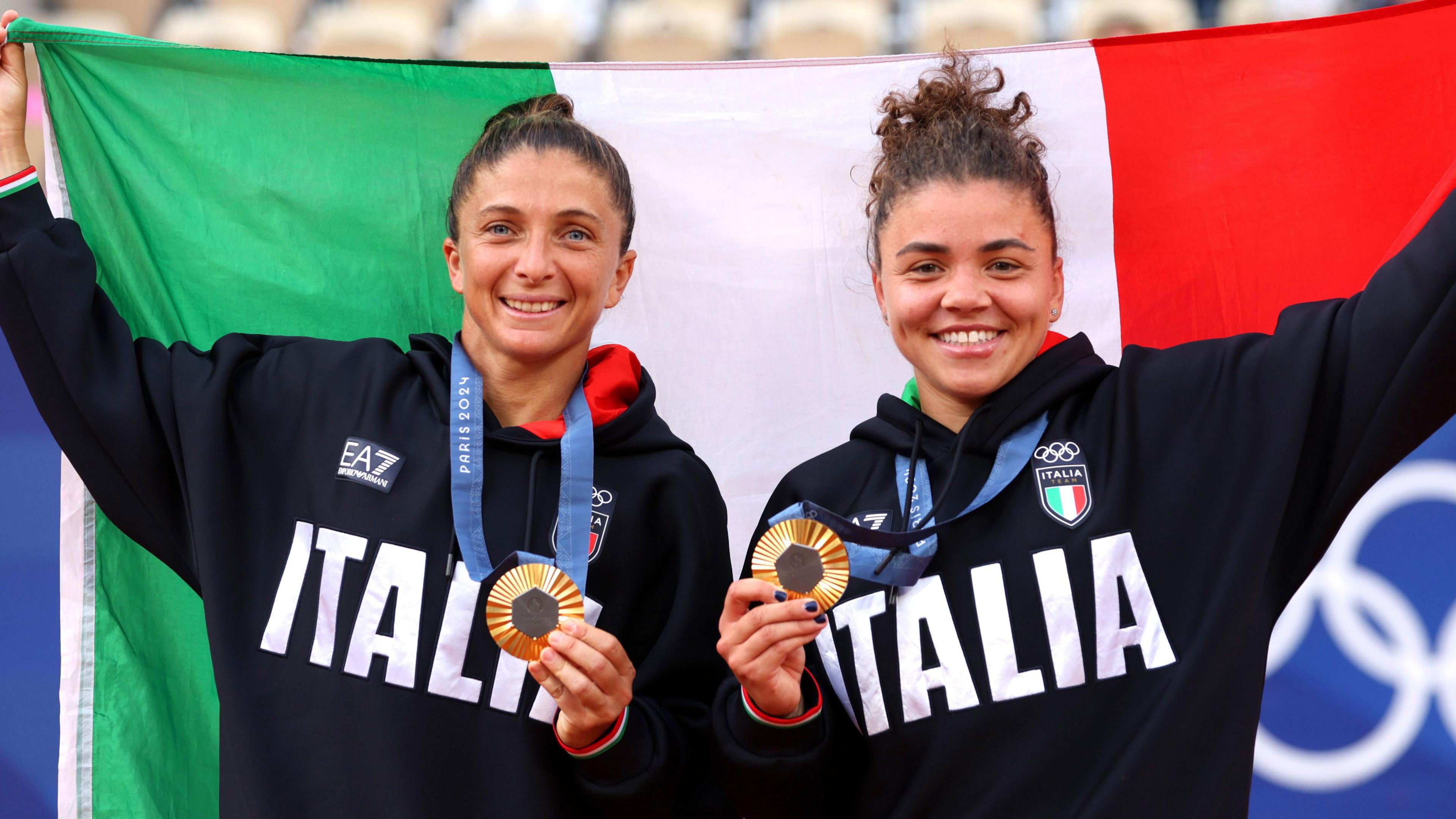 Sara Errani and Jasmine Paolini lift the Italian flag after winning Olympic gold at Paris 2024