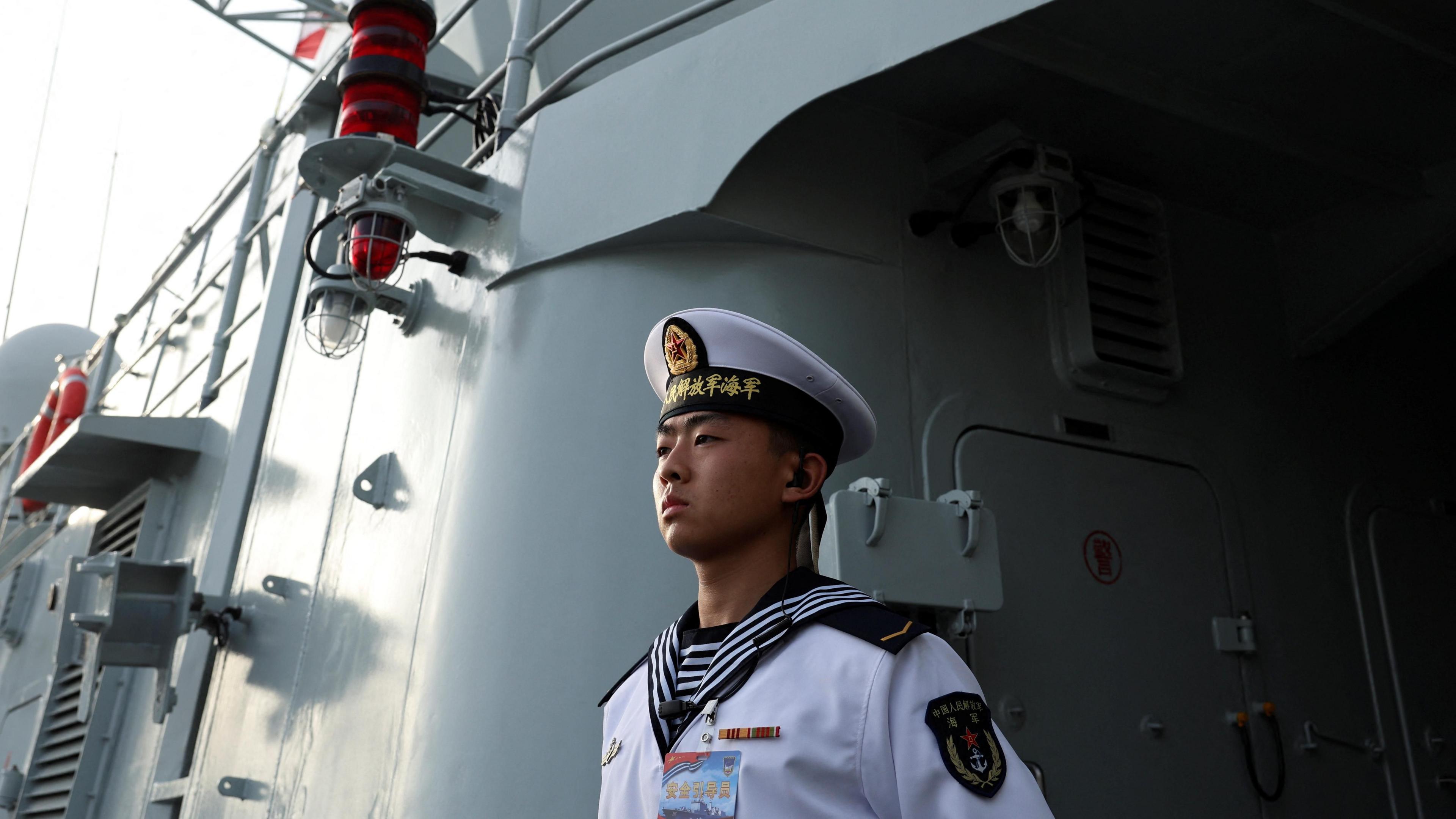 A member of the Chinese People's Liberation Army (PLA) Navy stands guard on the Shijiazhuang, a Type 051C guided-missile destroyer, as the Navy opens warships for public viewing to mark its upcoming 75th founding anniversary, at the port in Qingdao, Shandong province, China 20 April 2024