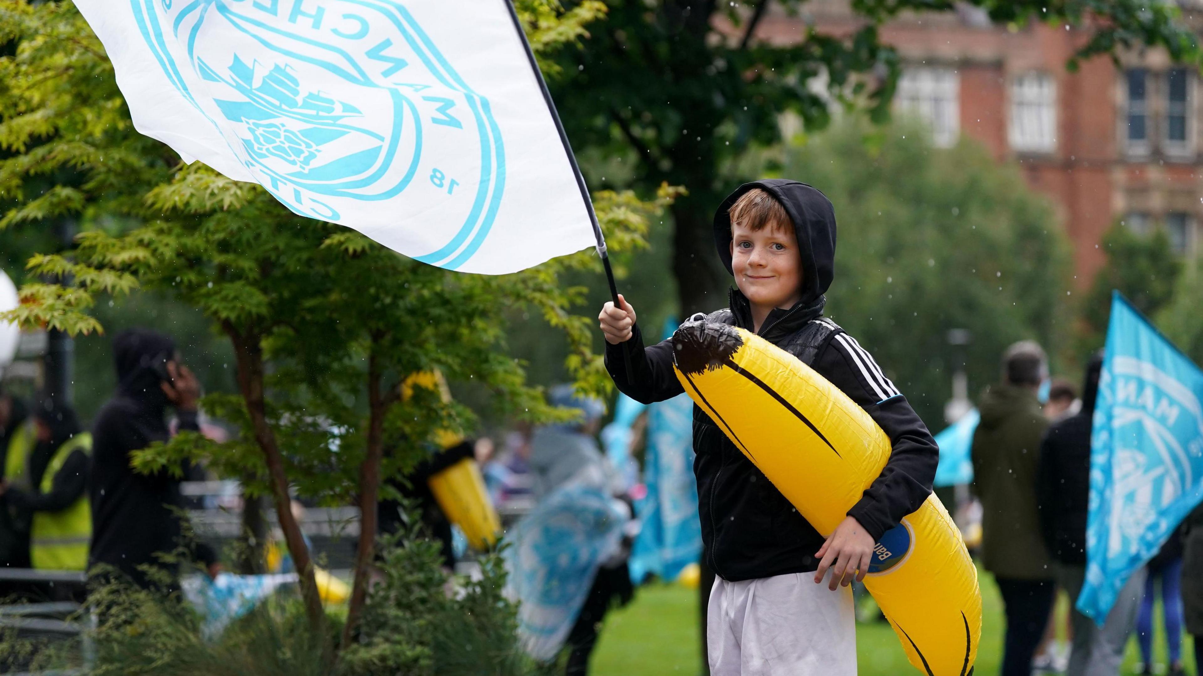 Fan with a flag and blow-up banana outside the National Football Museum