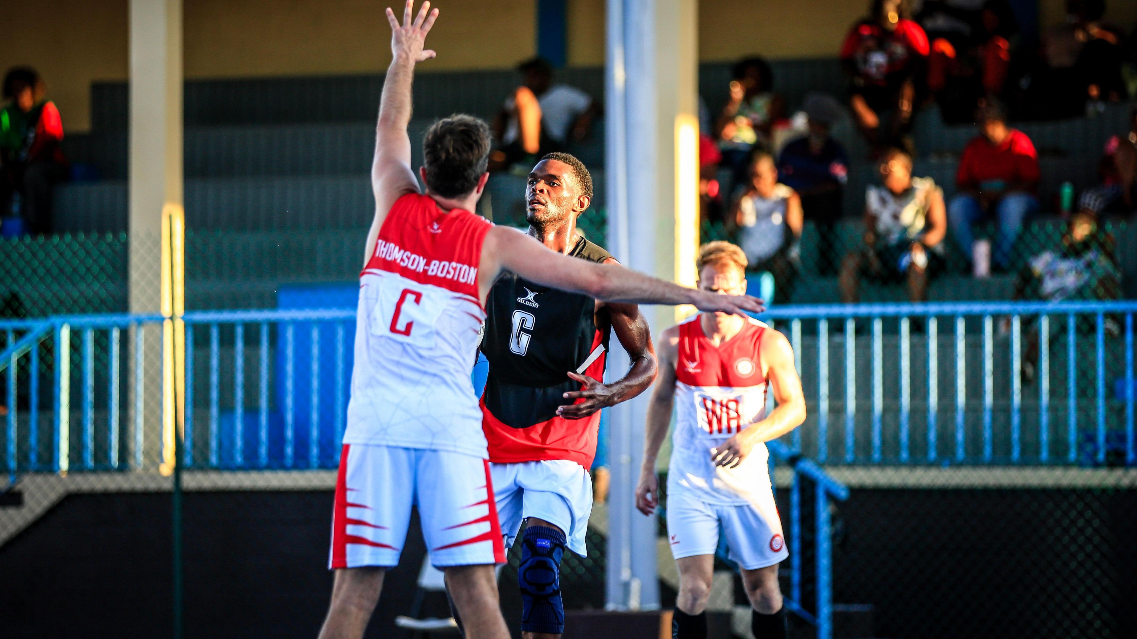 James Thomson-Boston reaches for the ball in an England netball match.