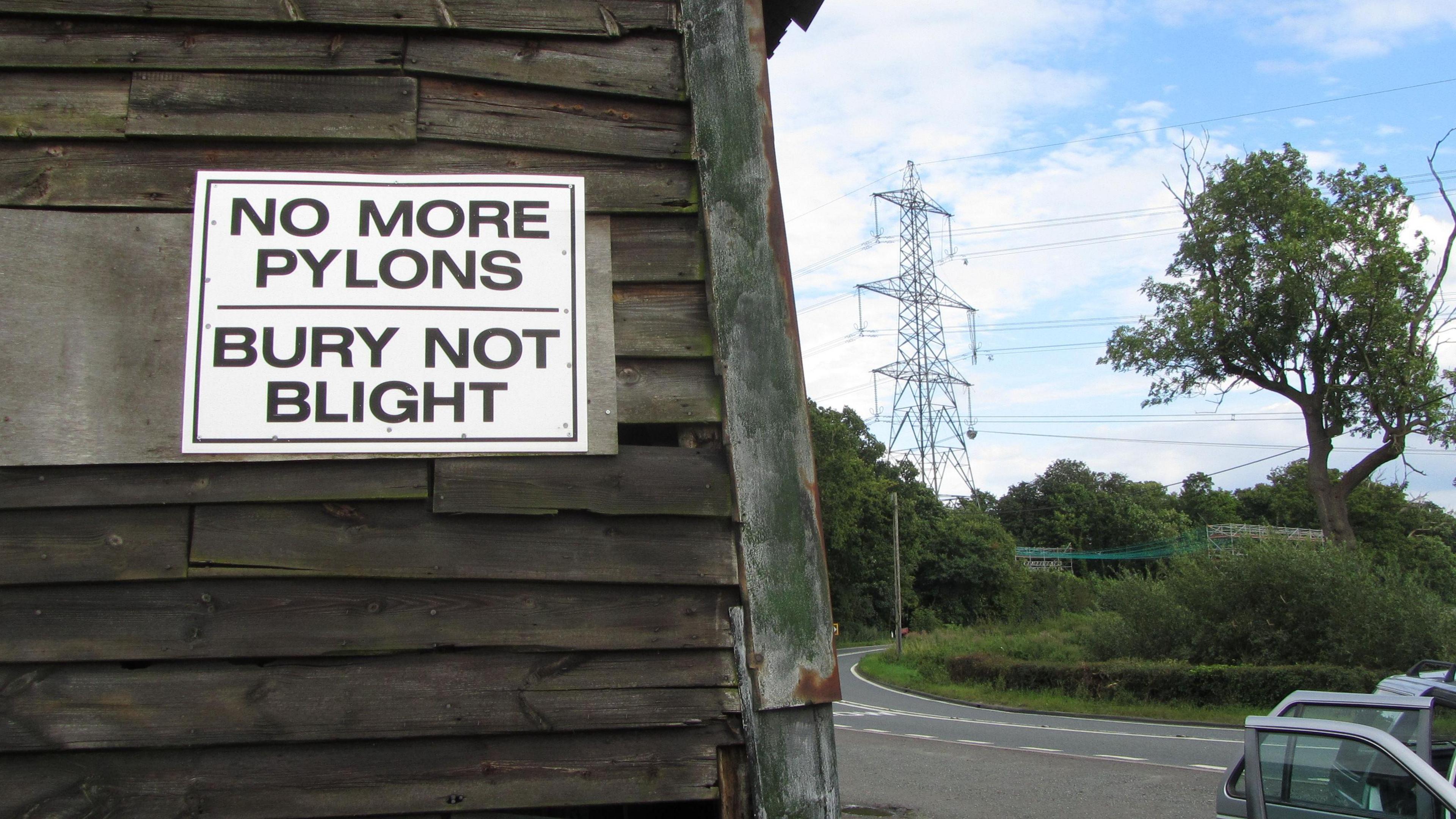 "No more pylons" placard on the side of a barn in Suffolk