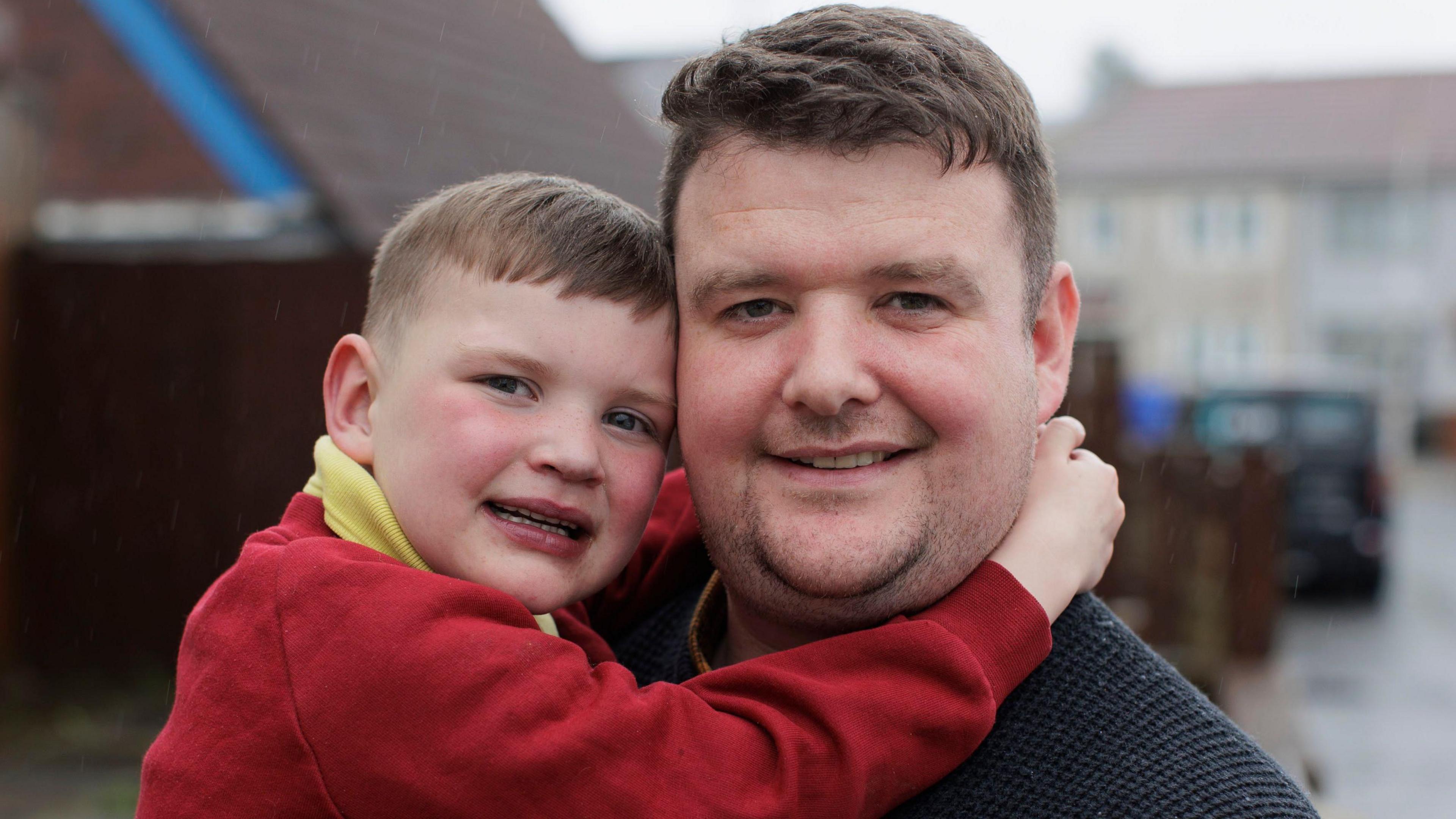 Mairtin Mac Gabhann holds his seven-year-old son Dáithí Mac Gabhann, pictured in school uniform. son 