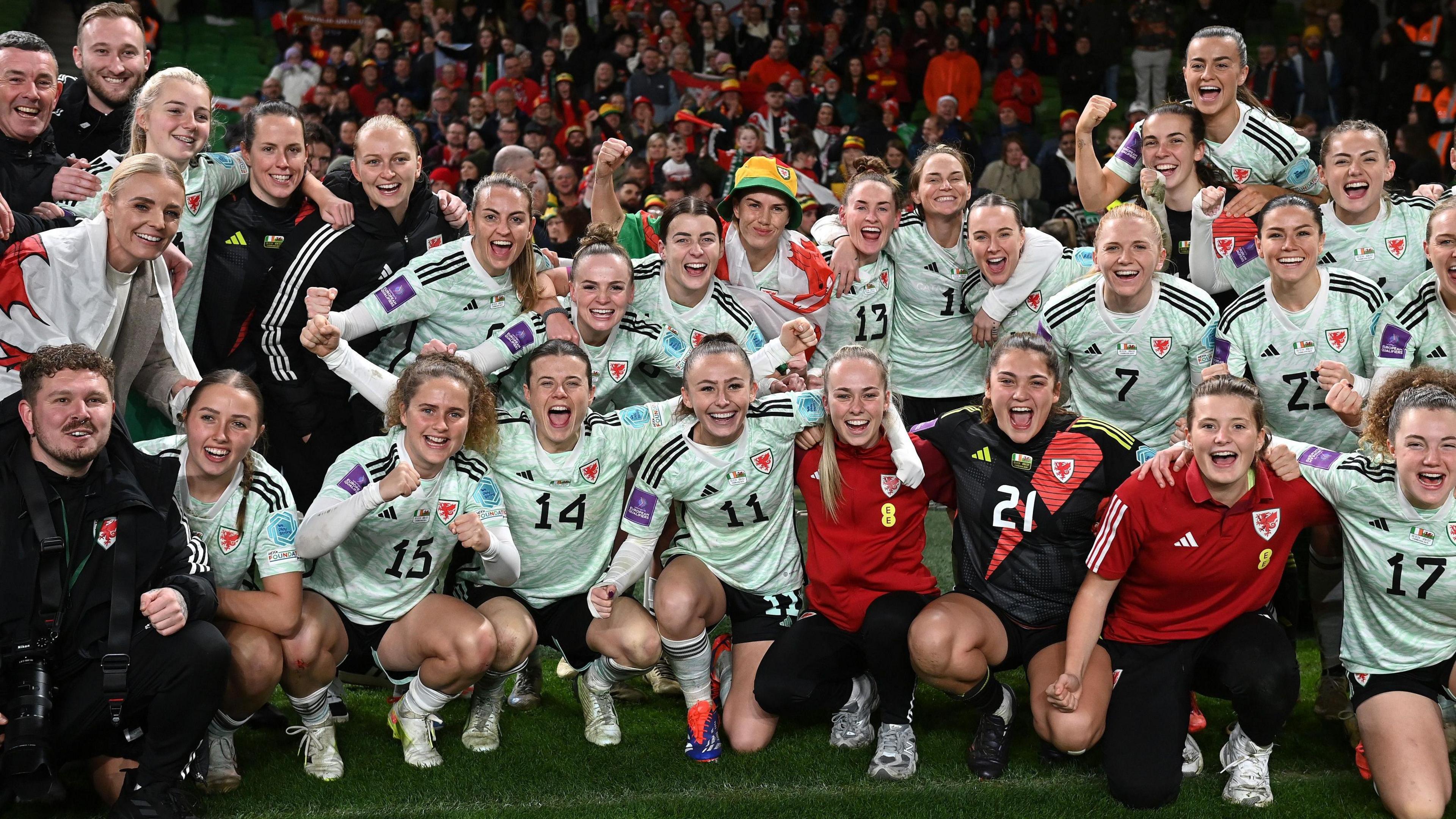 Players of Wales pose for team a photo following victory in the UEFA Women's EURO 2025. 