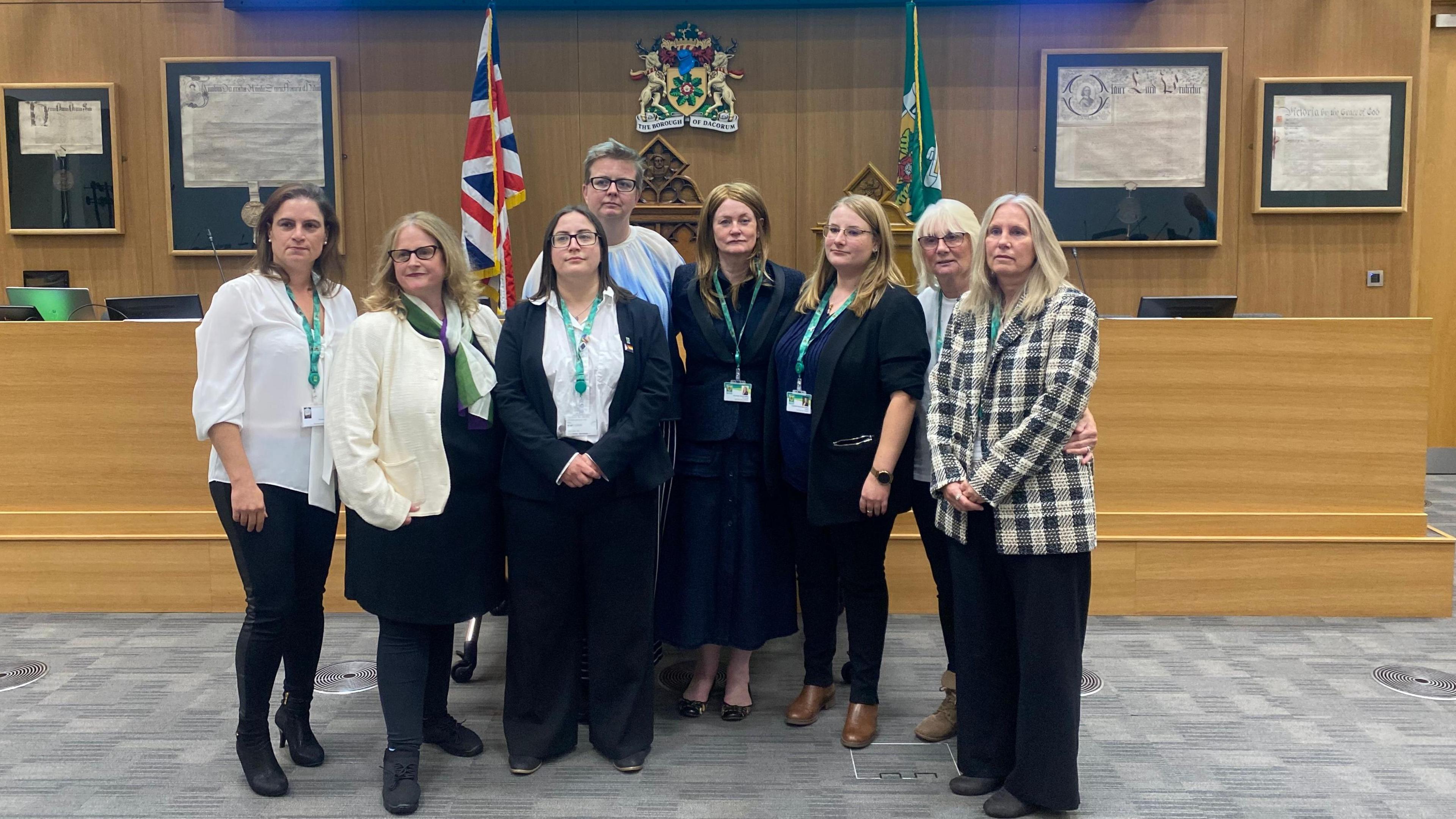 The eight female Liberal Democrat councillors who resigned the party whip stand in a council chamber.