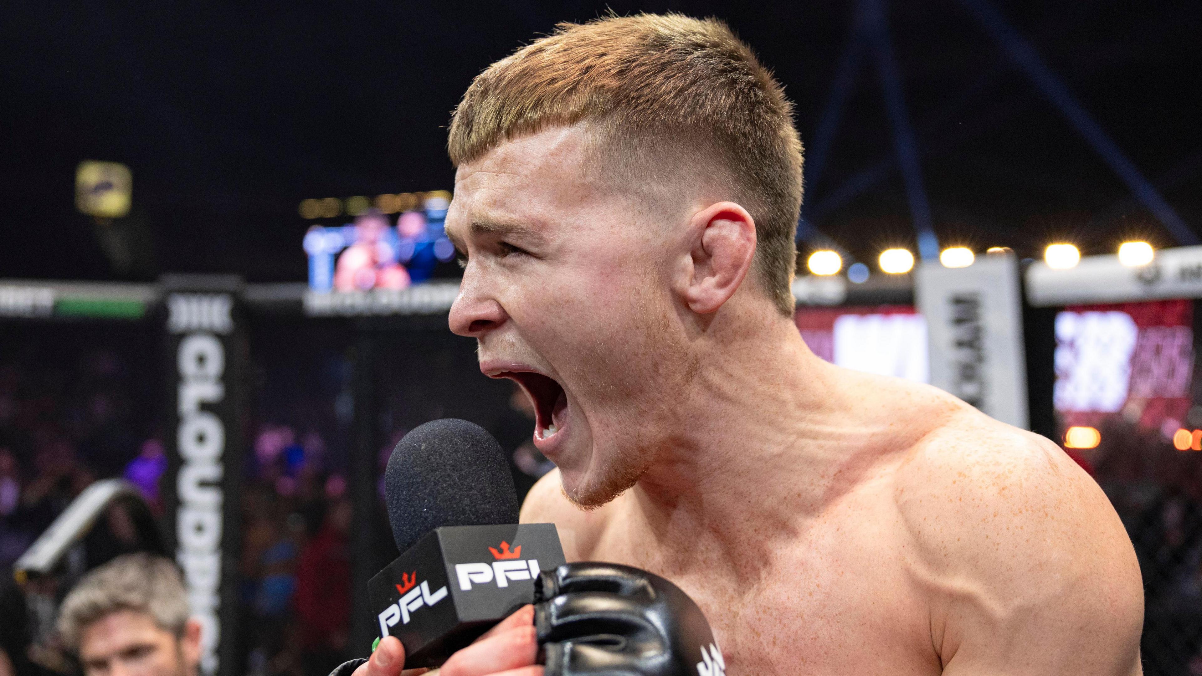 Paul Hughes shouts into a PFL microphone in the cage