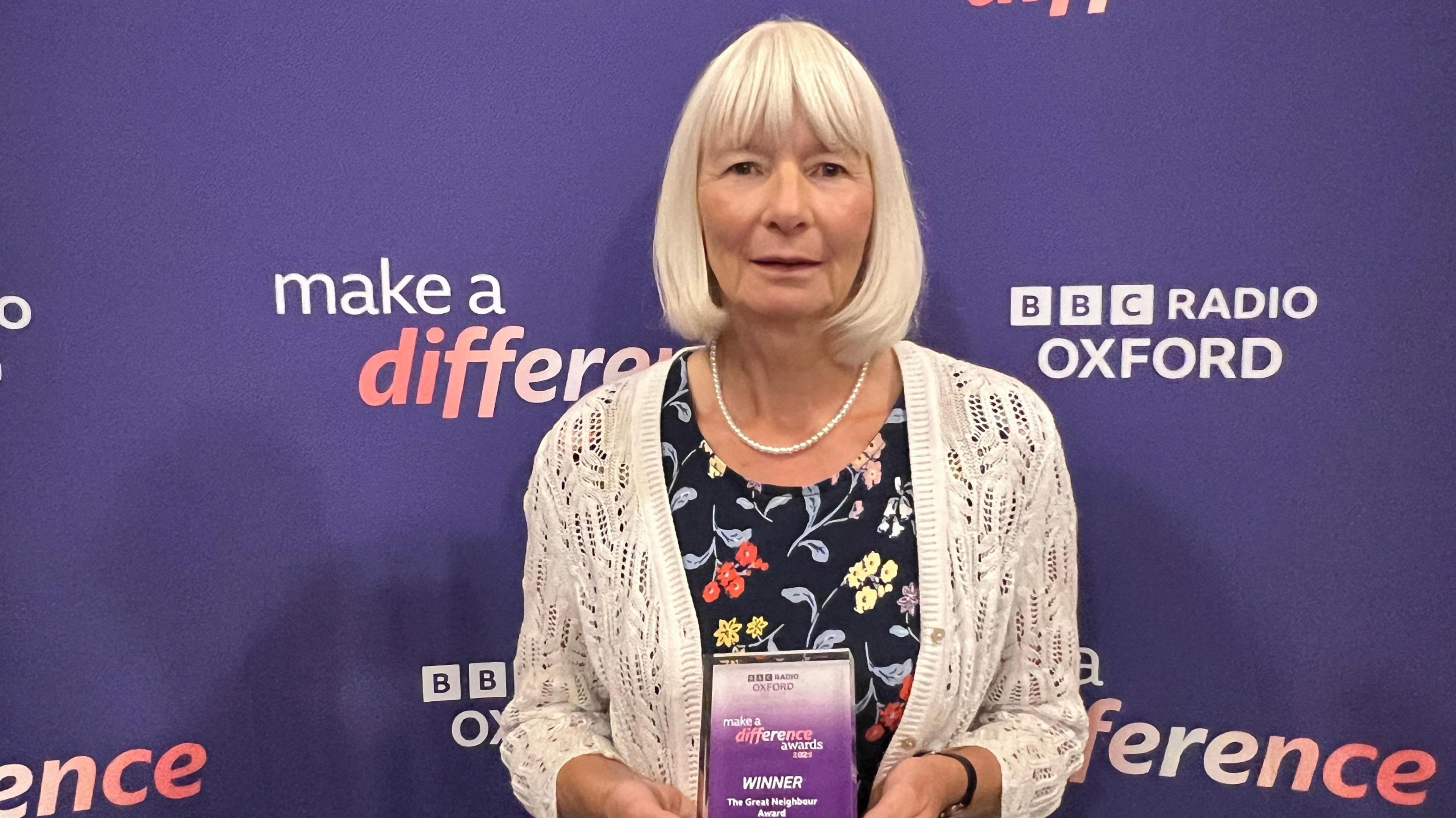 Margo Evans holding her Make a Difference Award trophy
