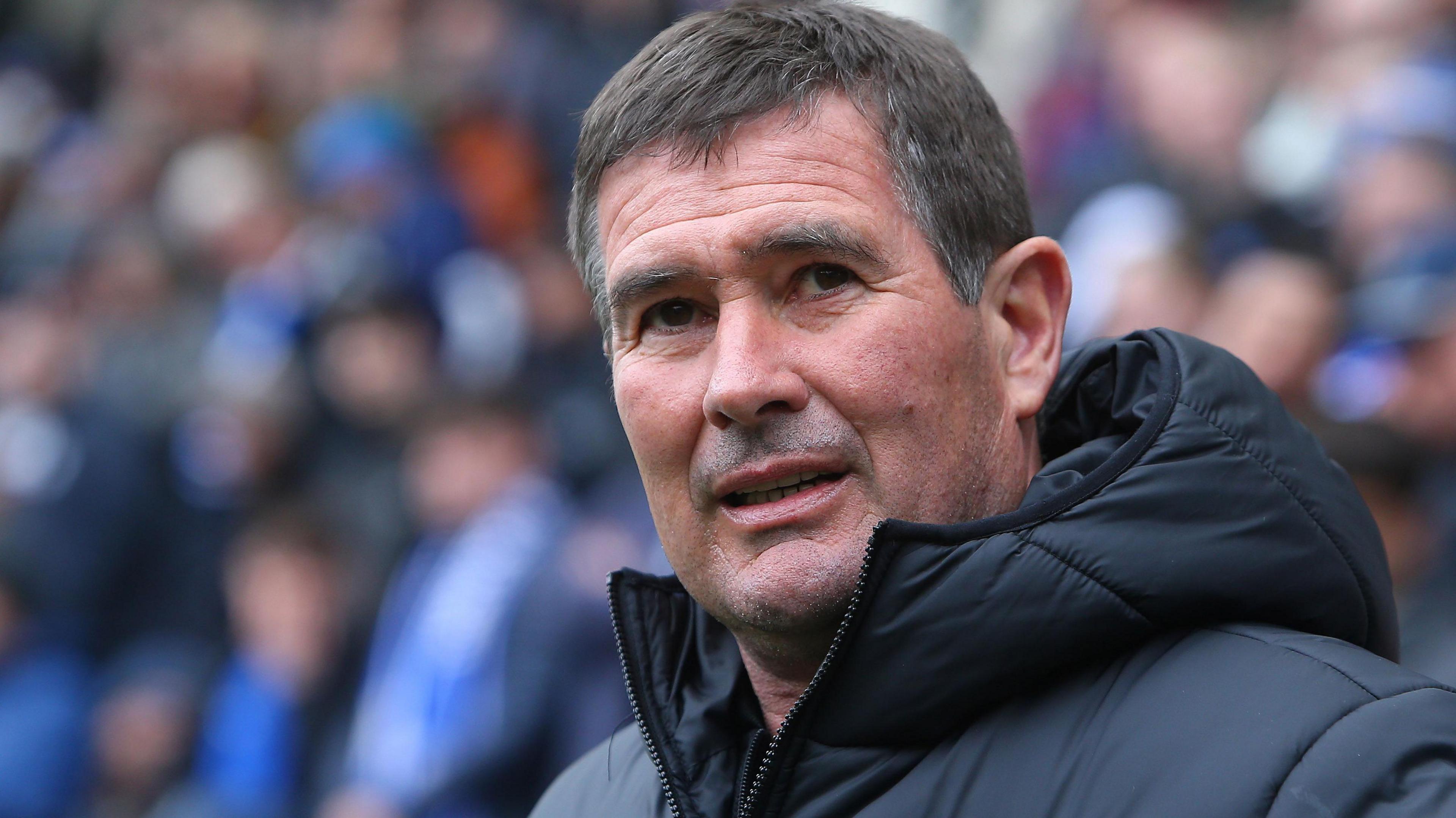 Nigel Clough in a black coat looks towards the camera
