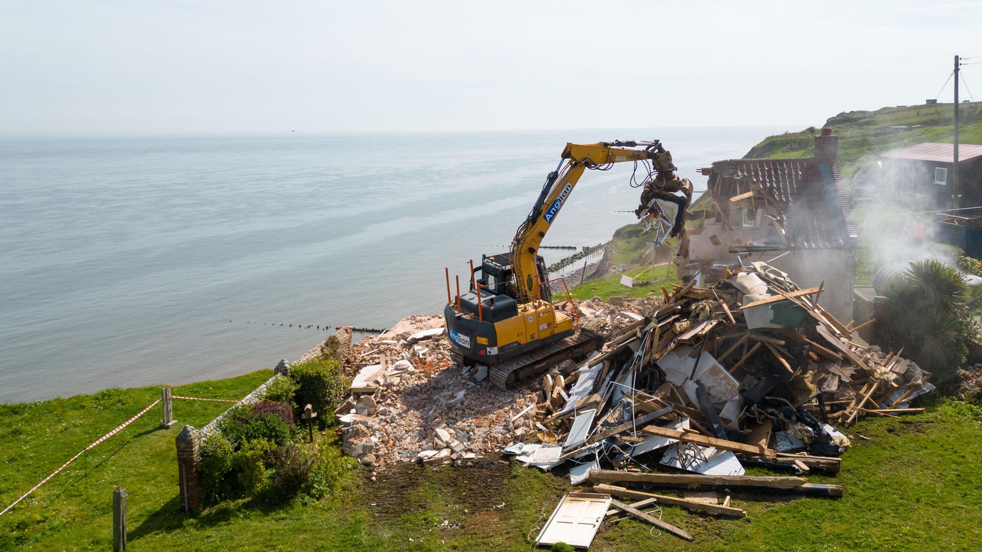 Plant destroying a farmhouse which is has almost been fully demolished