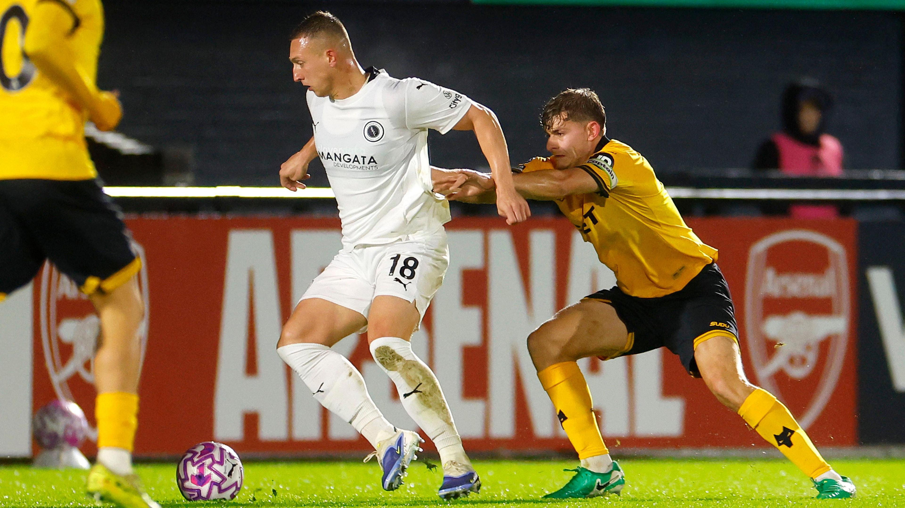 Luke Norris shields the ball for Boreham Wood in last season's National League Cup tie as Wolverhampton Wanderers' under-21 player Alfie Pond holds on to his jersey from behind 