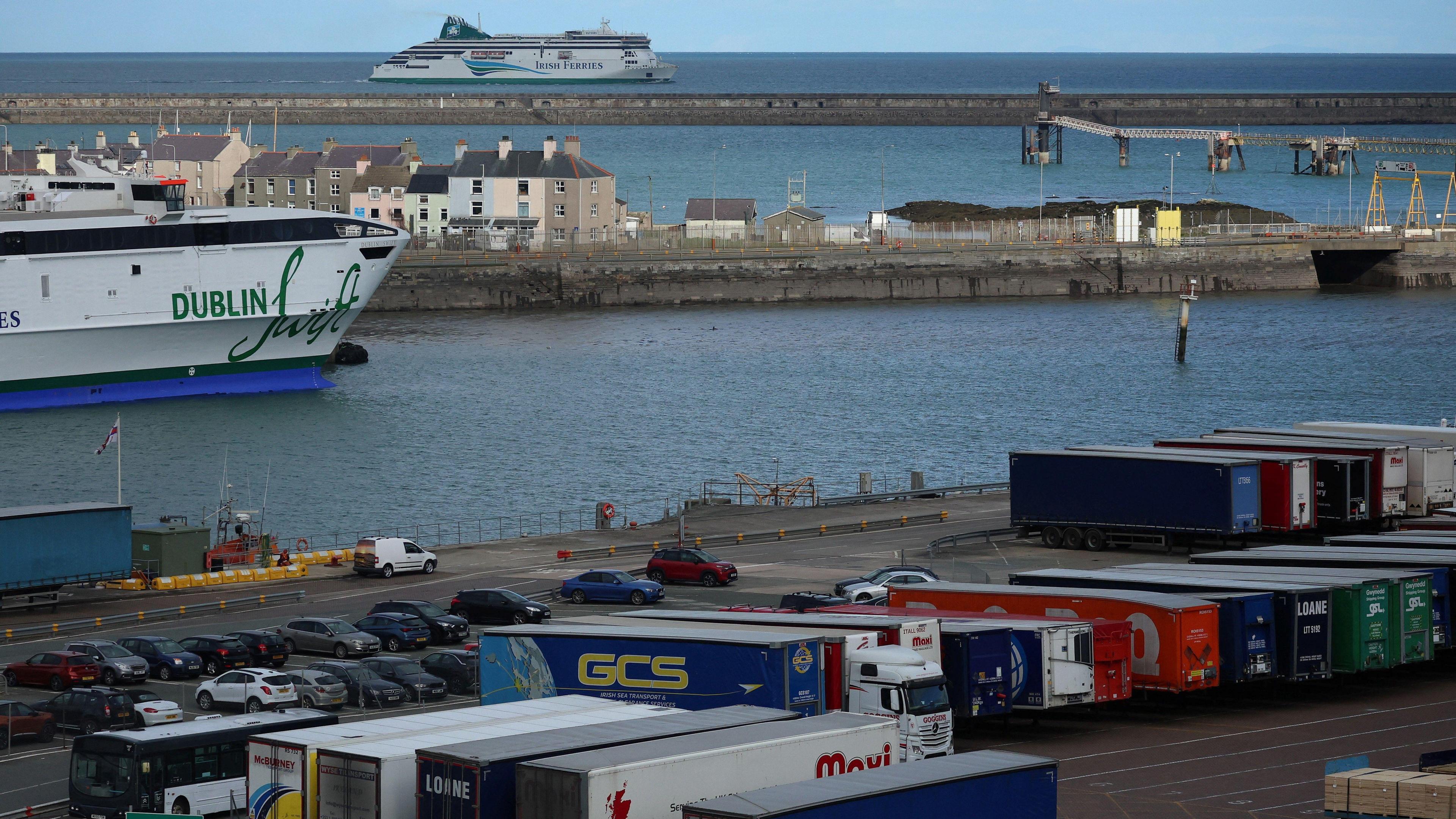 An Irish Ferries vessel in a harbour, with shipping container on the dock side