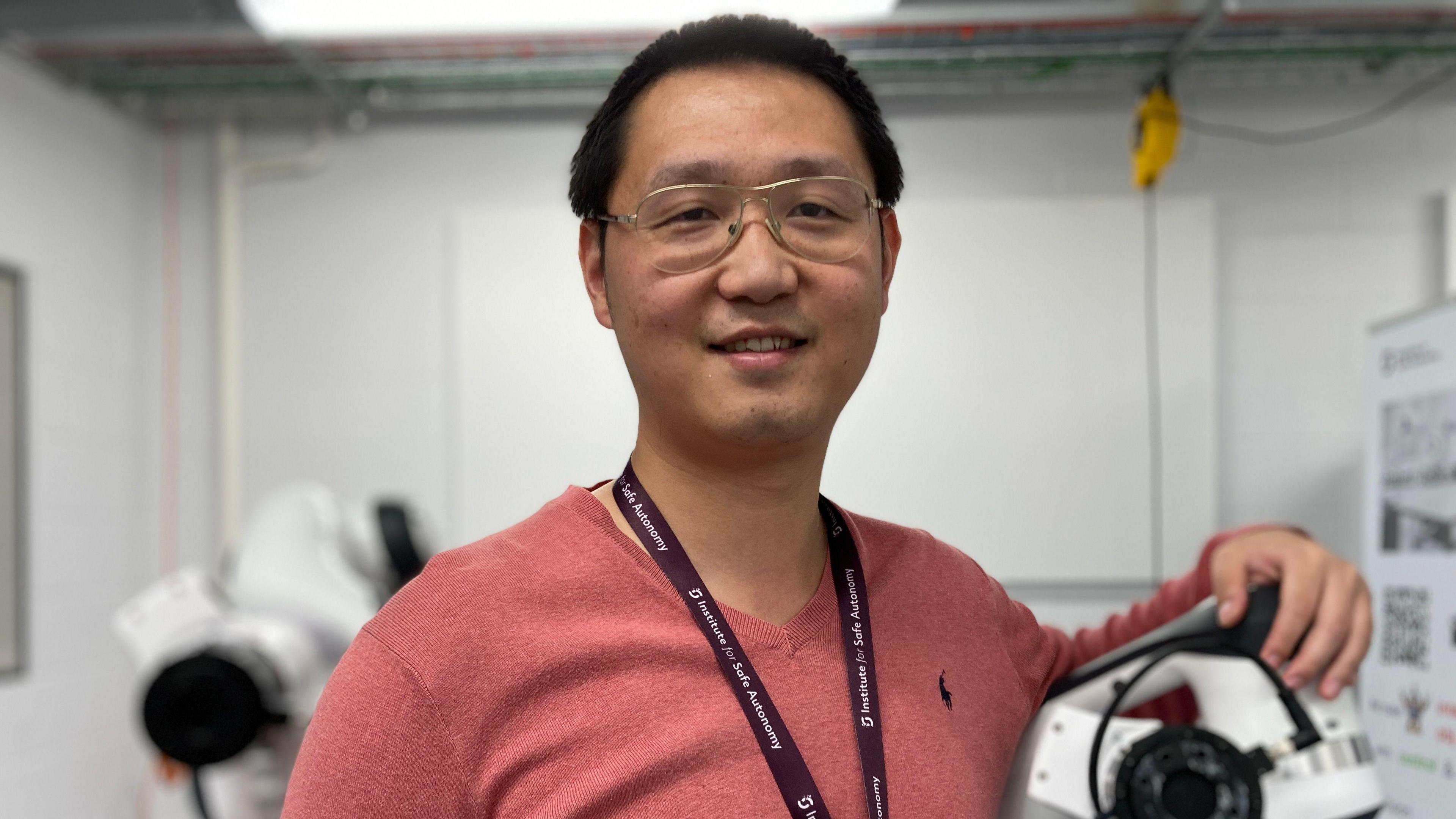 Dr Jihong Zhu wearing pink jumper in his laboratory