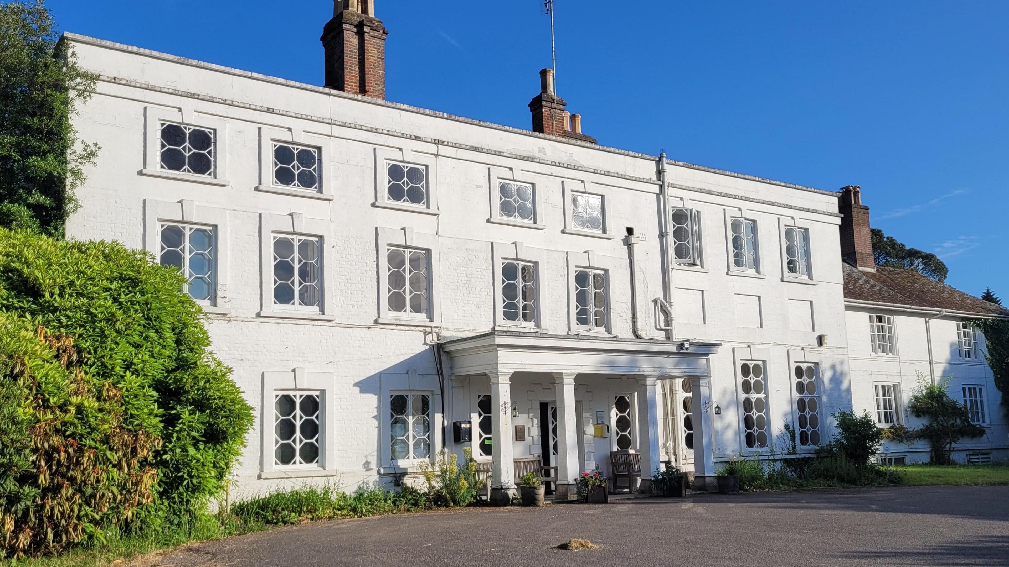 Exterior of Foxlease - whitewashed Georgian house with three storeys