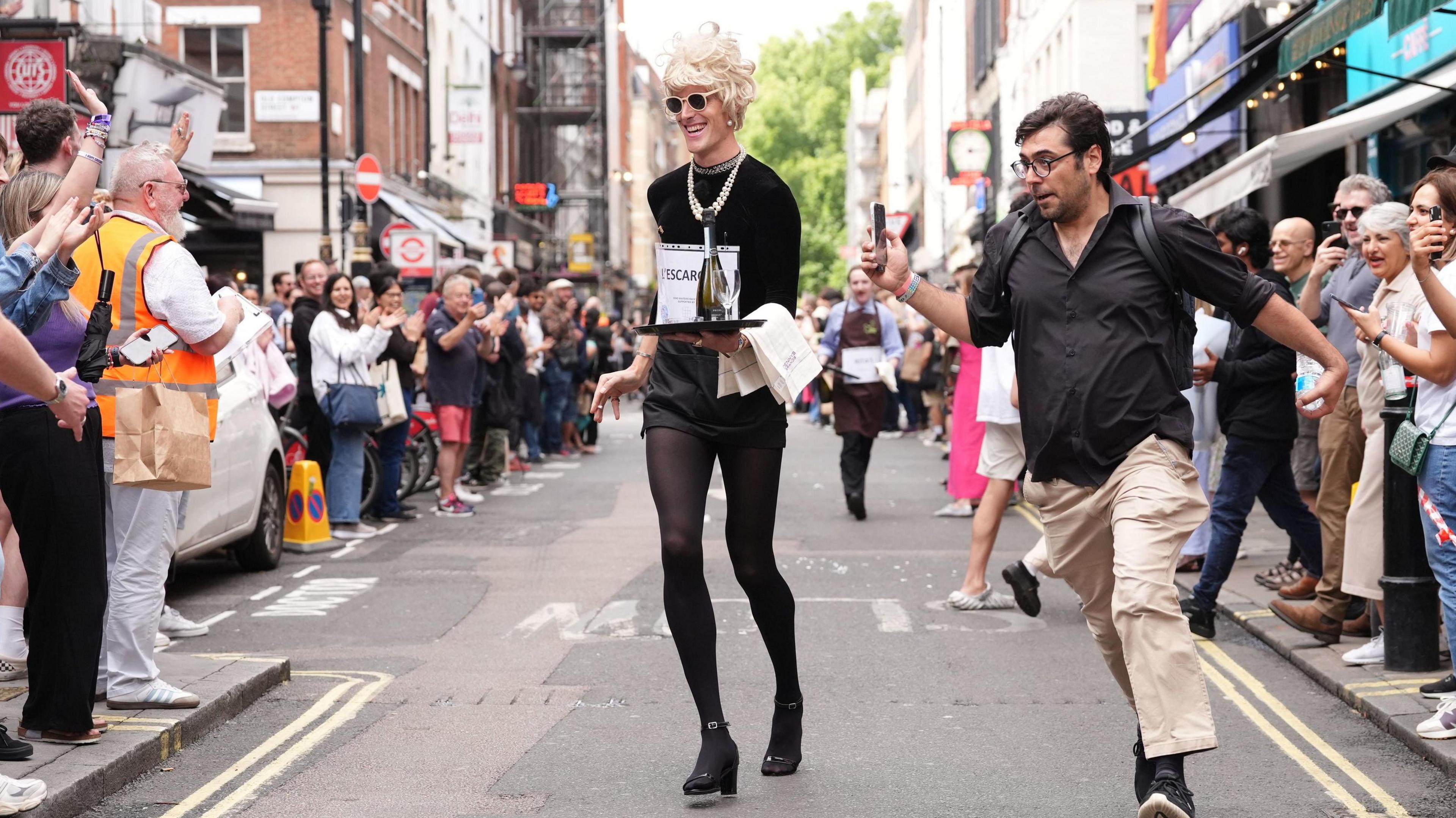 People participate in the Soho Waiter's Race at the 50th Soho Village Fete in central London. Soho's waiters, hospitality and bar staff race their way through the streets of Soho in a bid to win a trophy and £100 cash prize. Picture date: Sunday July 20, 2025