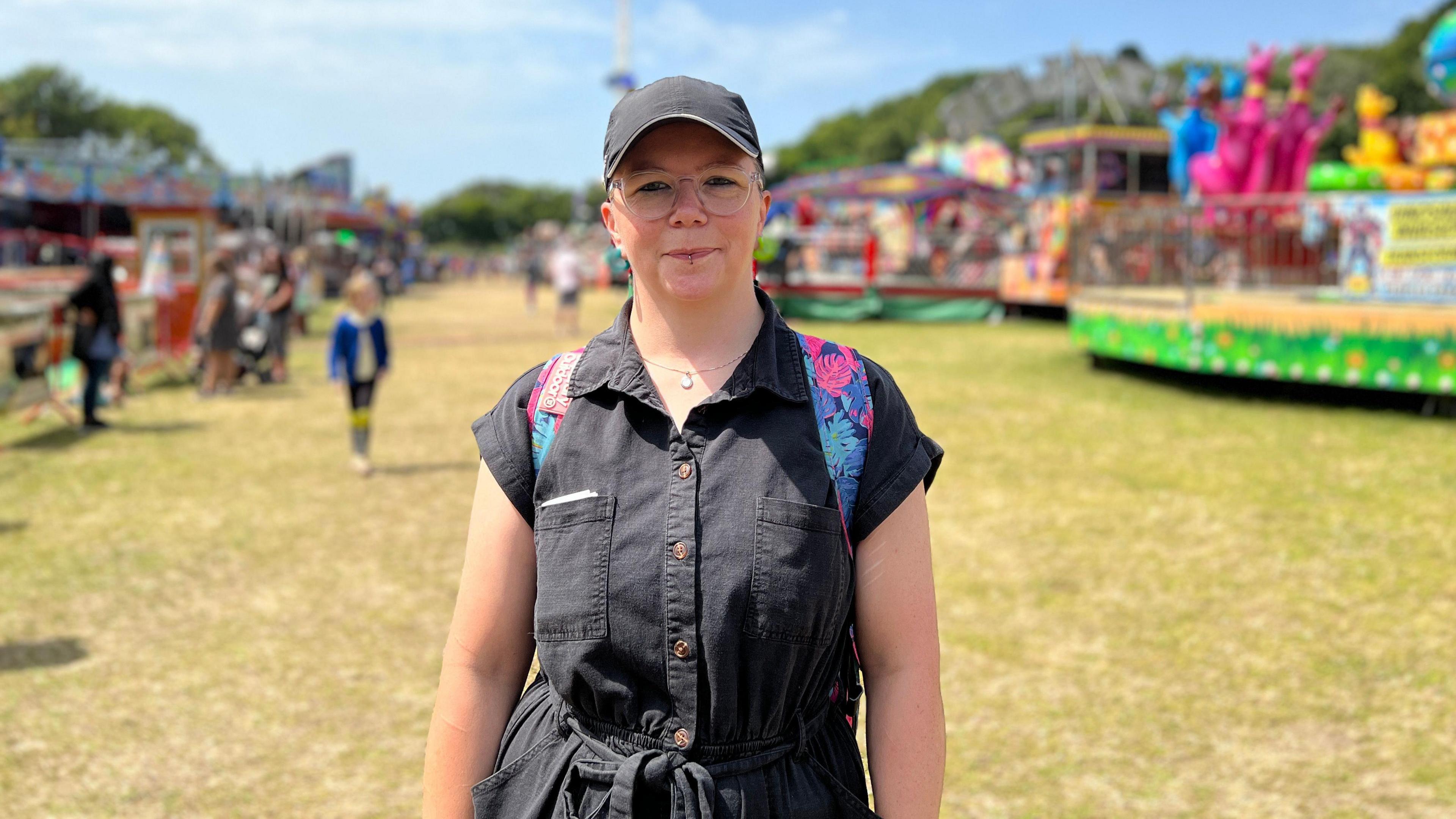 Lorraine looks at the camera as the funfair is behind her