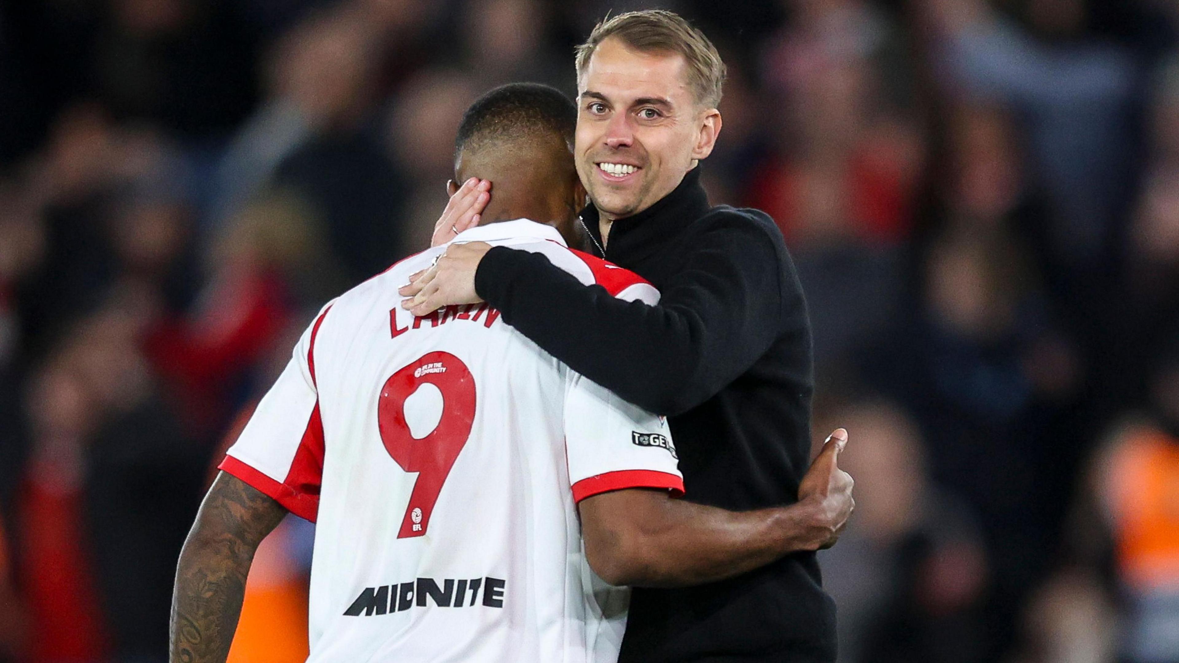 Tonda Eckert has a big smile on his face as he hugs Cyle Larin (LARIN 9) at the end of the match 