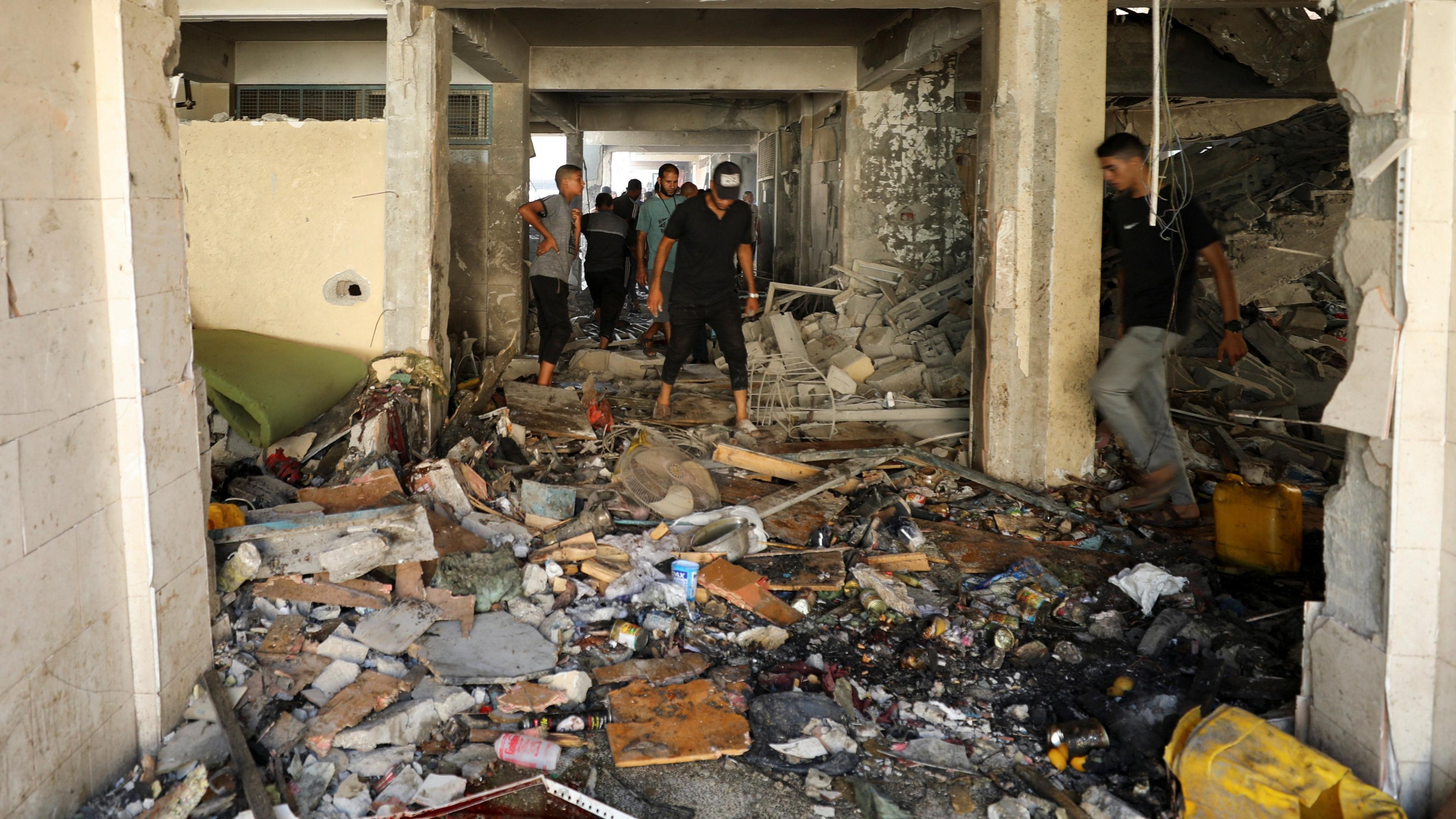 Palestinians inspect a school, which was sheltering displaced people, after it was hit by an Israeli strike, amid the Israel-Hamas conflict, in Gaza City