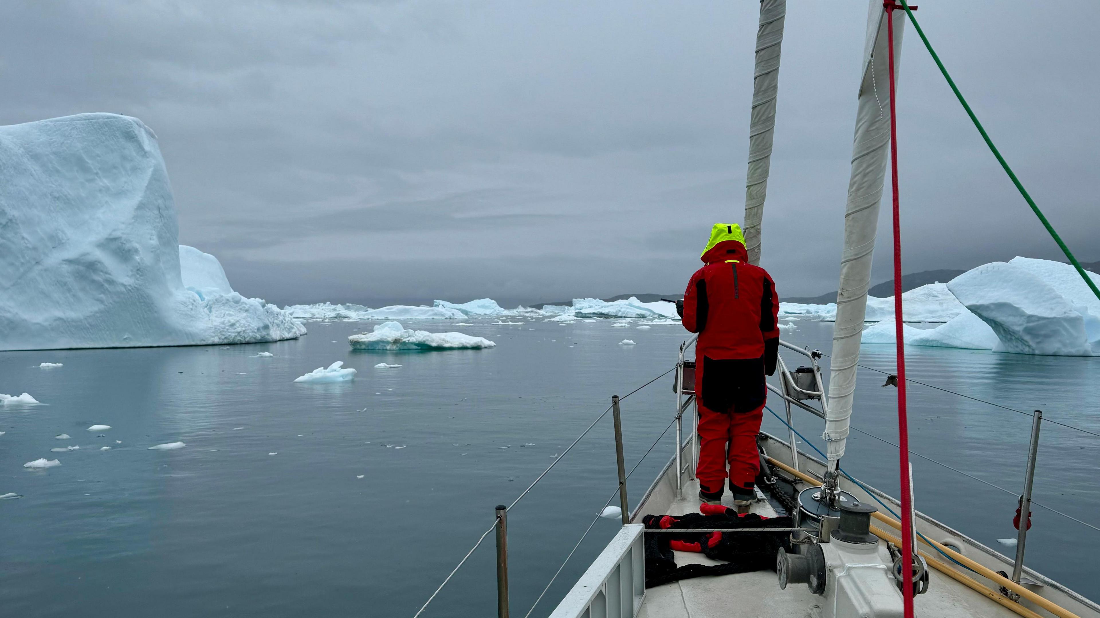 Alex Rockström at the helm of the Abel Tasman looks out at an iceberg-filled sea off the coast of western Greenland.