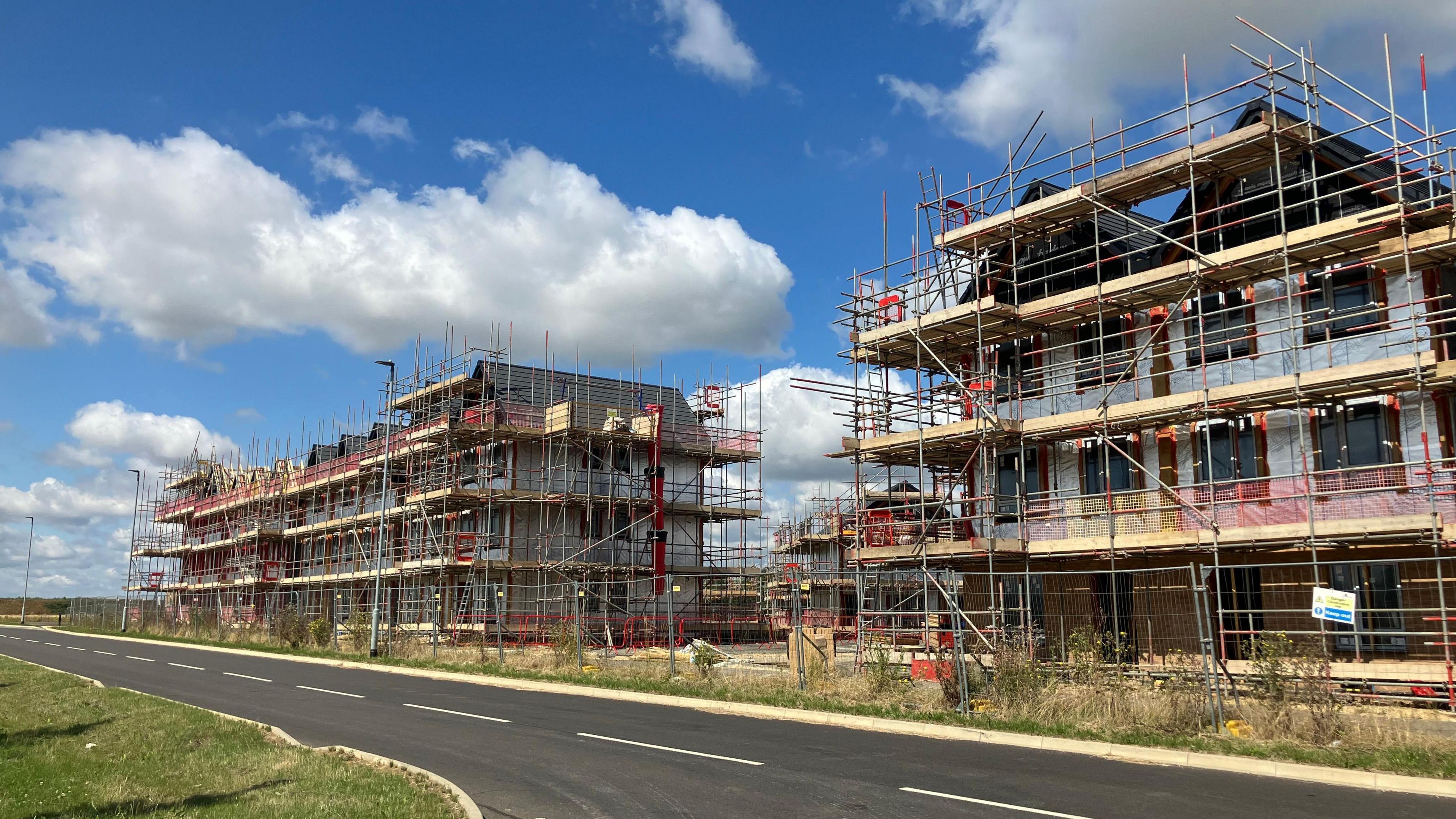 Exterior of  houses under construction with scaffolding in front 