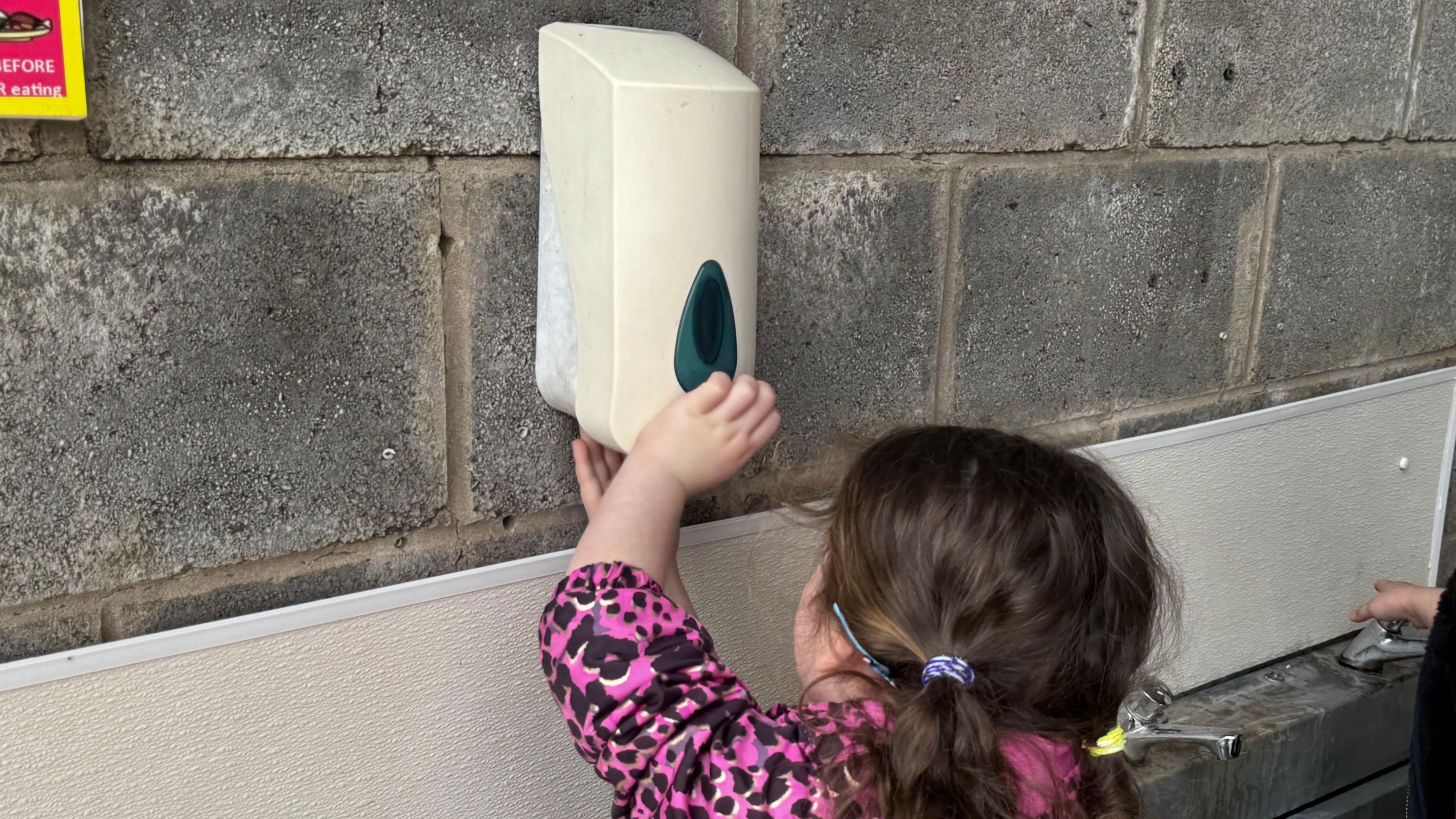 Merch ifanc yn golchi ei dwylo ar fferm