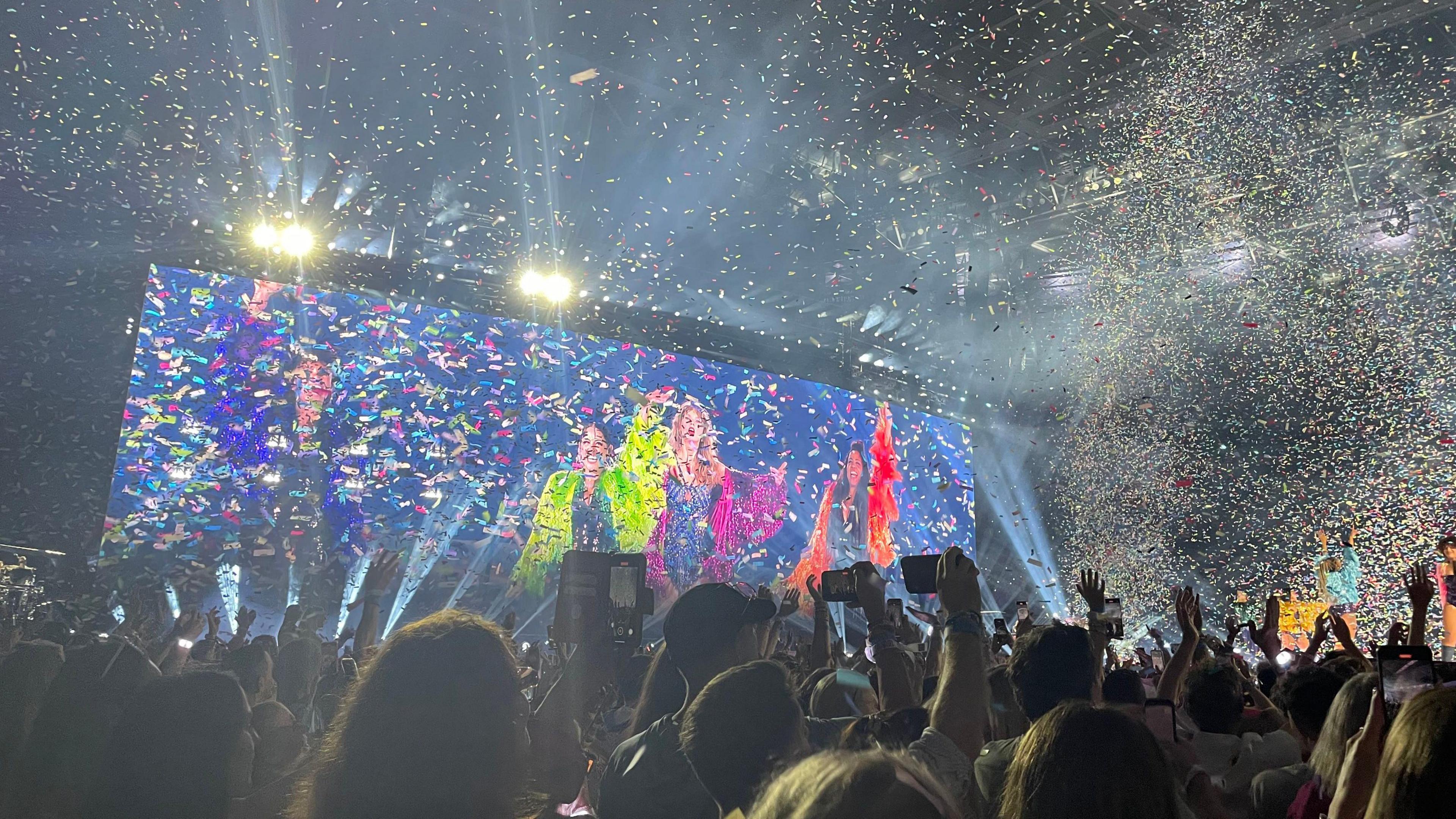 A photo from the crowd showing confetti going off during the Taylor Swift concert at Wembley, with fans holding their phones in the air