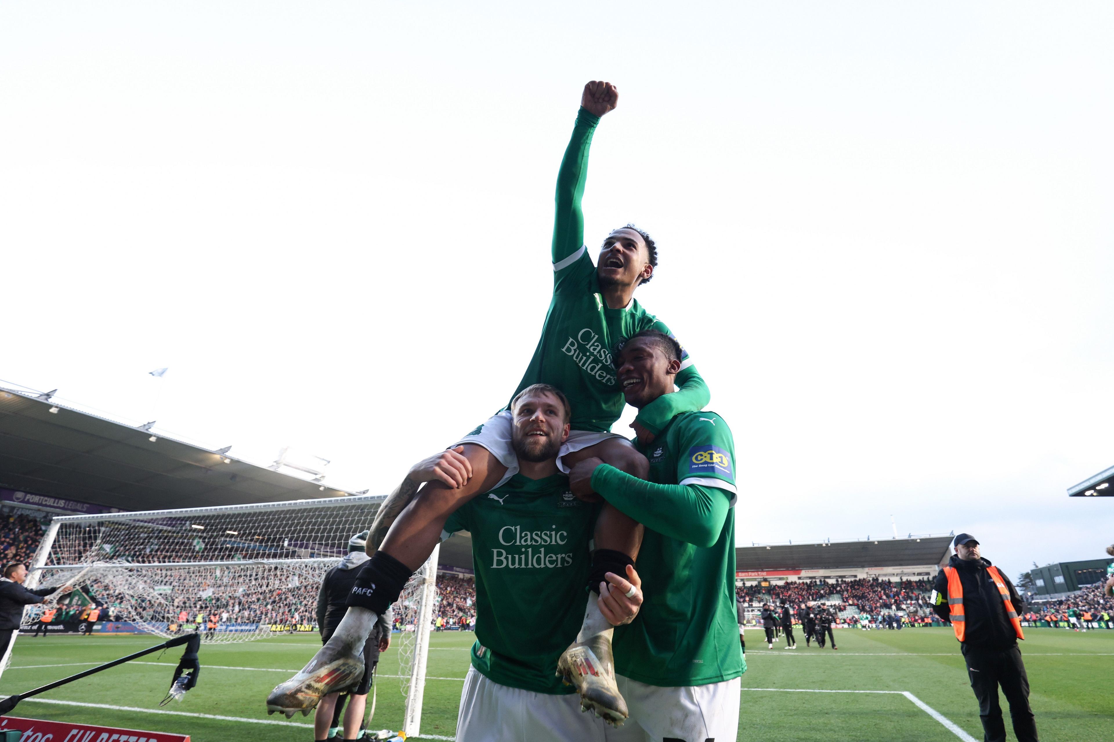 Tymoteusz Puchacz of Plymouth Argyle, Muhamed Tijani of Plymouth Argyle and Matthew Sorinola of Plymouth Argyle celebrate victory during the Emirates FA Cup Fourth Round match between Plymouth Argyle and Liverpool at Home Park