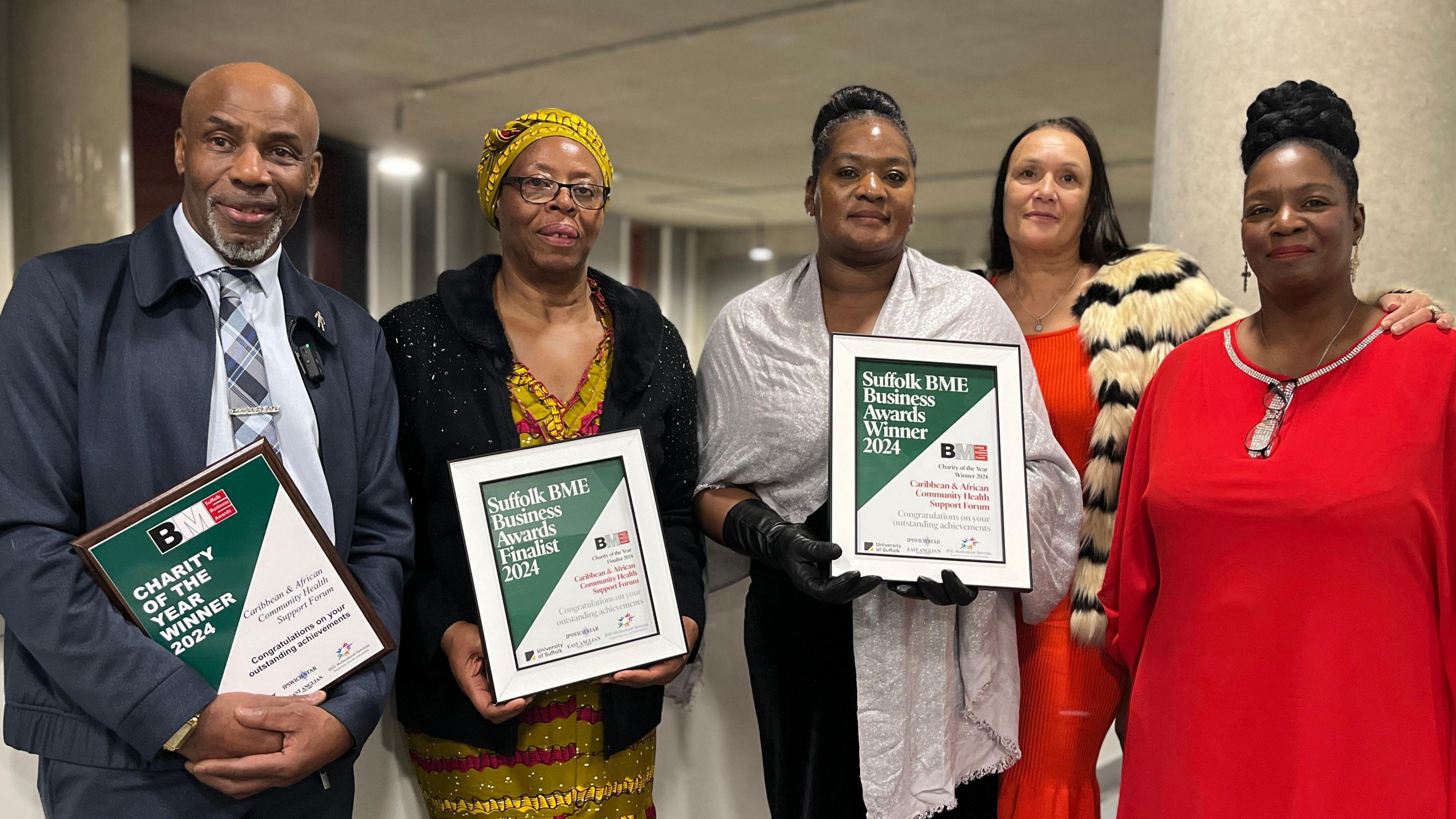 Clem Turner, Veronica Akrofi, Beverley Uter, Lydia Forrester and Angelina Quamina MBE from the Caribbean and African Community Health Support Forum - standing inside the University of Suffolk holding award certificates.