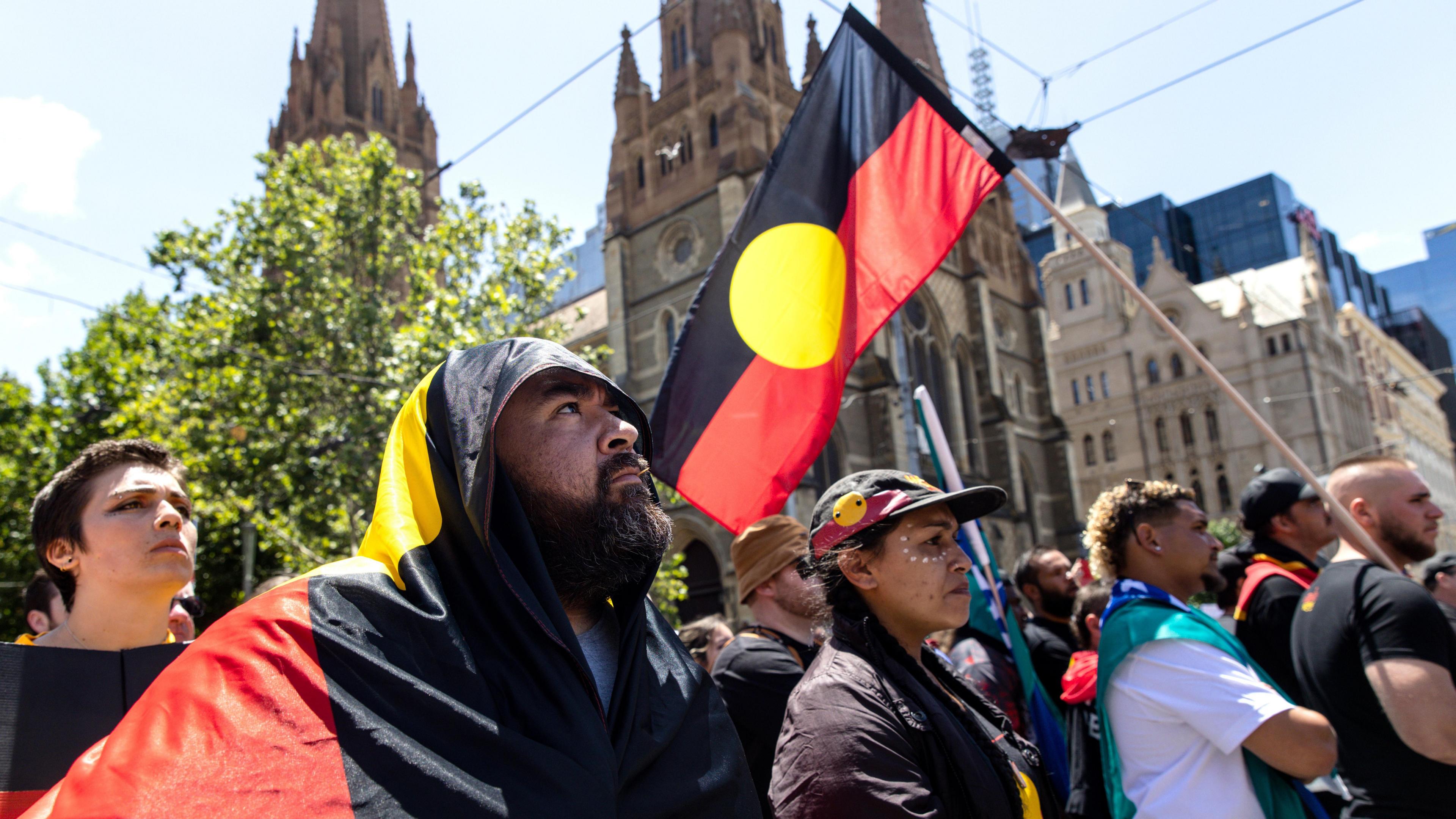 Demonstrators with Aboriginal flags participate in an Invasion Day rally