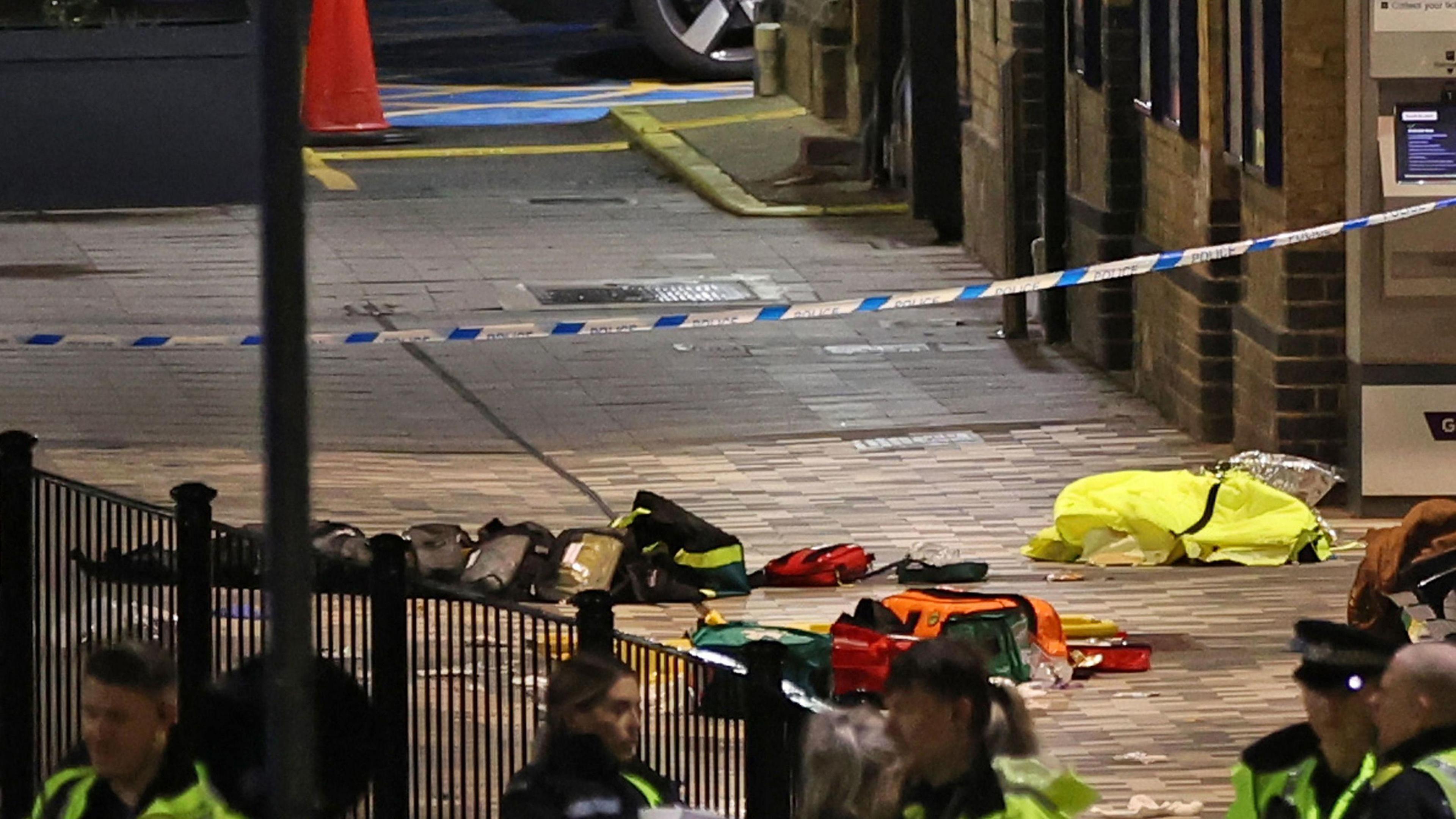Police tape over an area with police equipment behind it