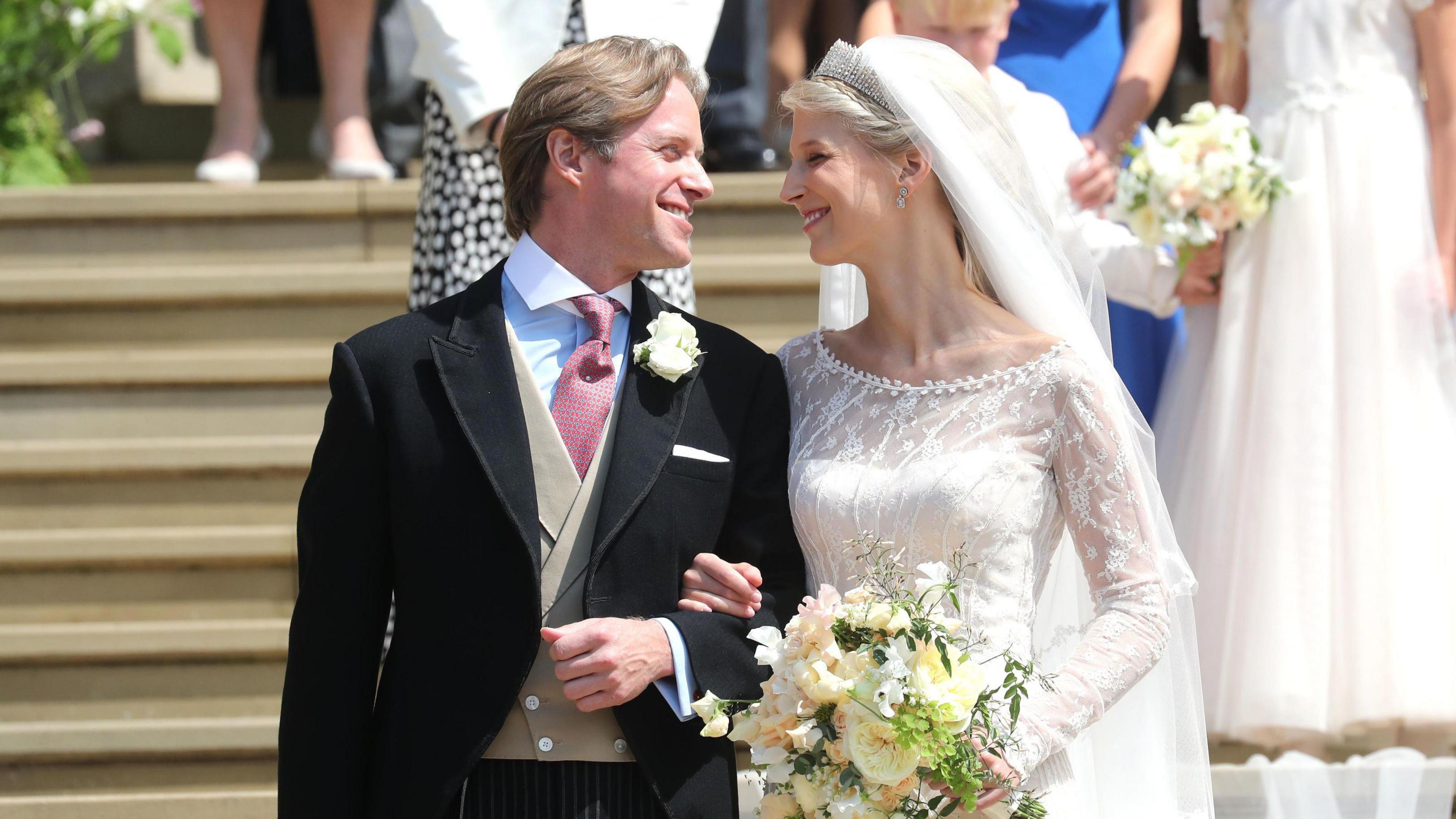 Thomas Kingston and Lady Gabriella Windsor smile on the steps of the chapel after their wedding at St George's Chapel in Windsor Castle