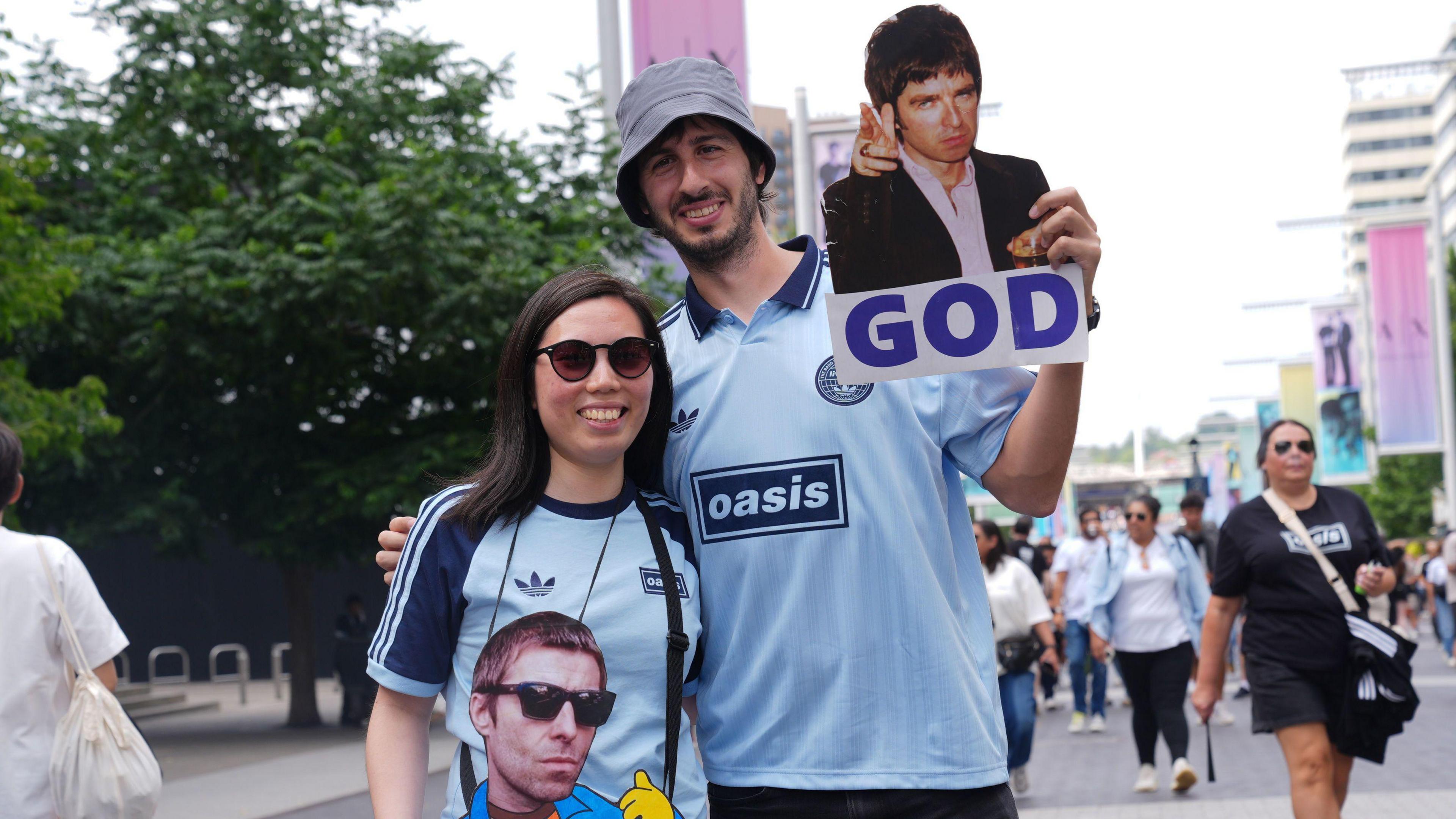 Fans holding posters of the Gallagher brothers.