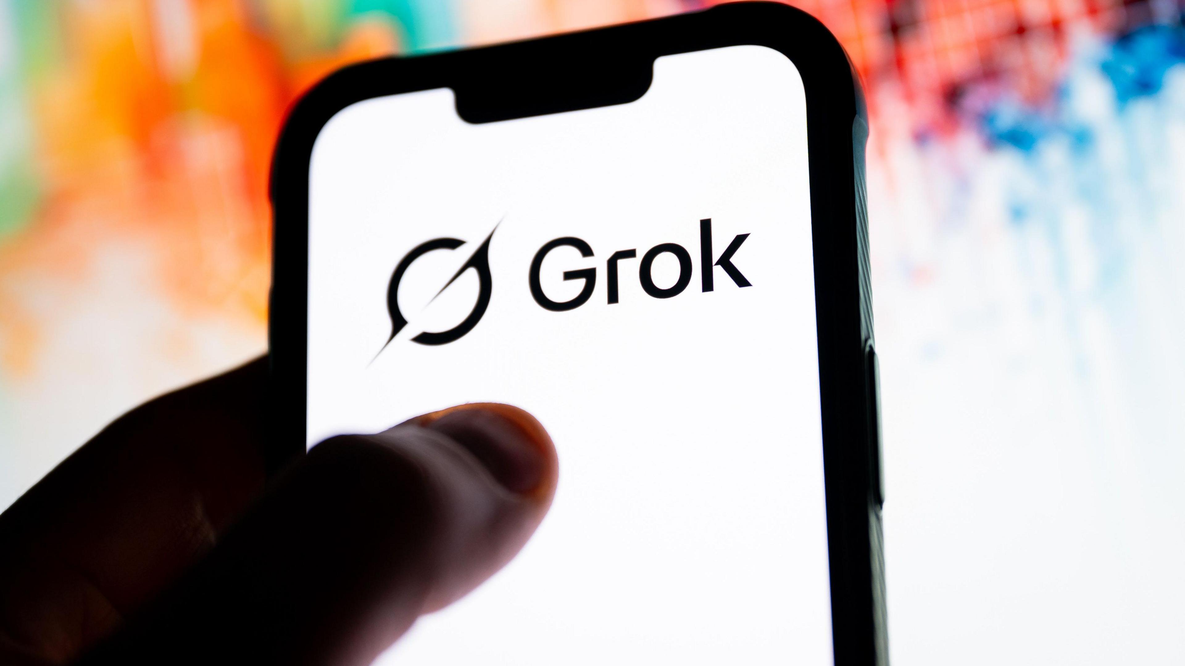 A phone with the Grok logo on it and a colourful background