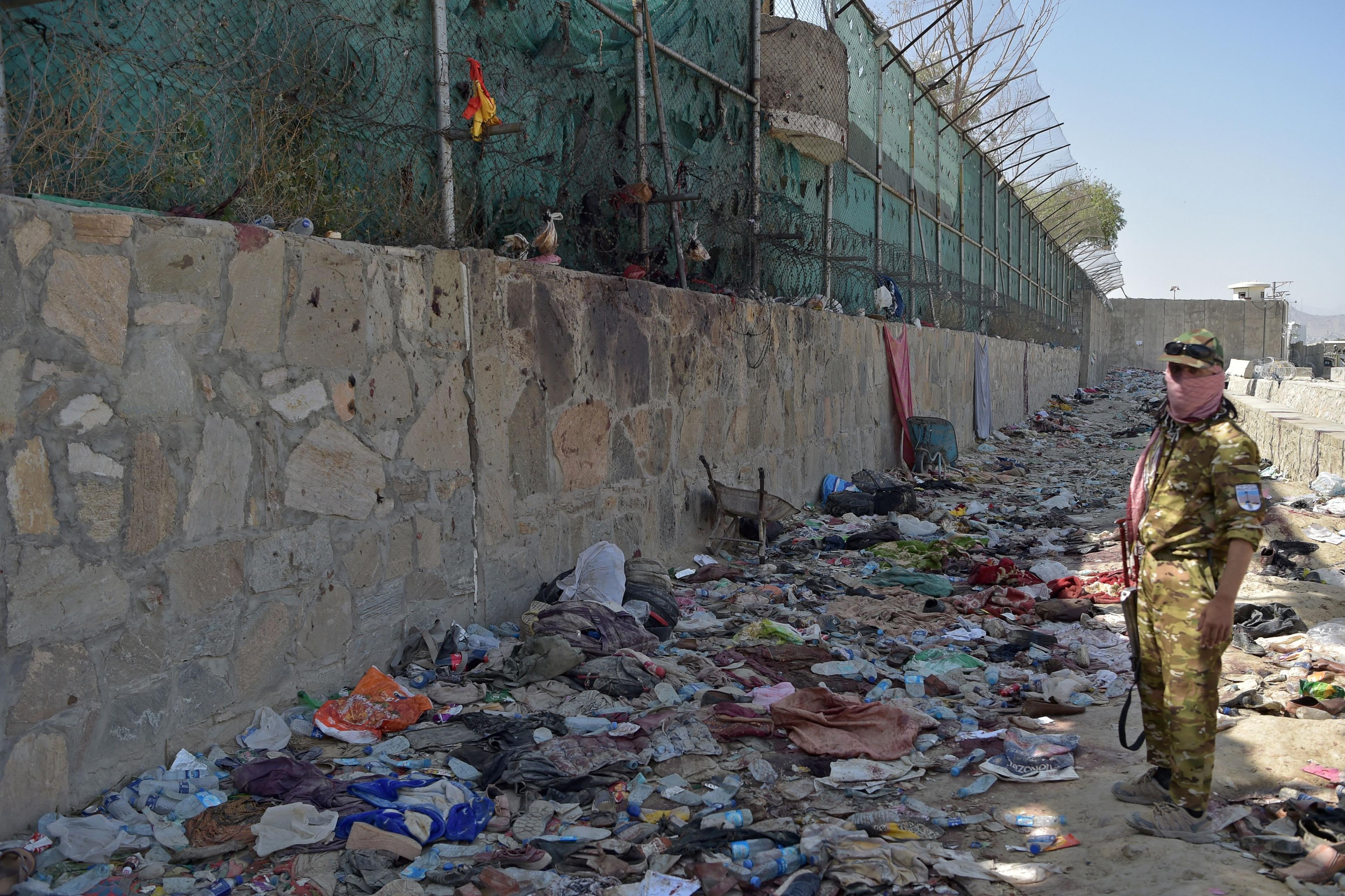 Taliban fighter stands guard at the site of the Kabul airport attack