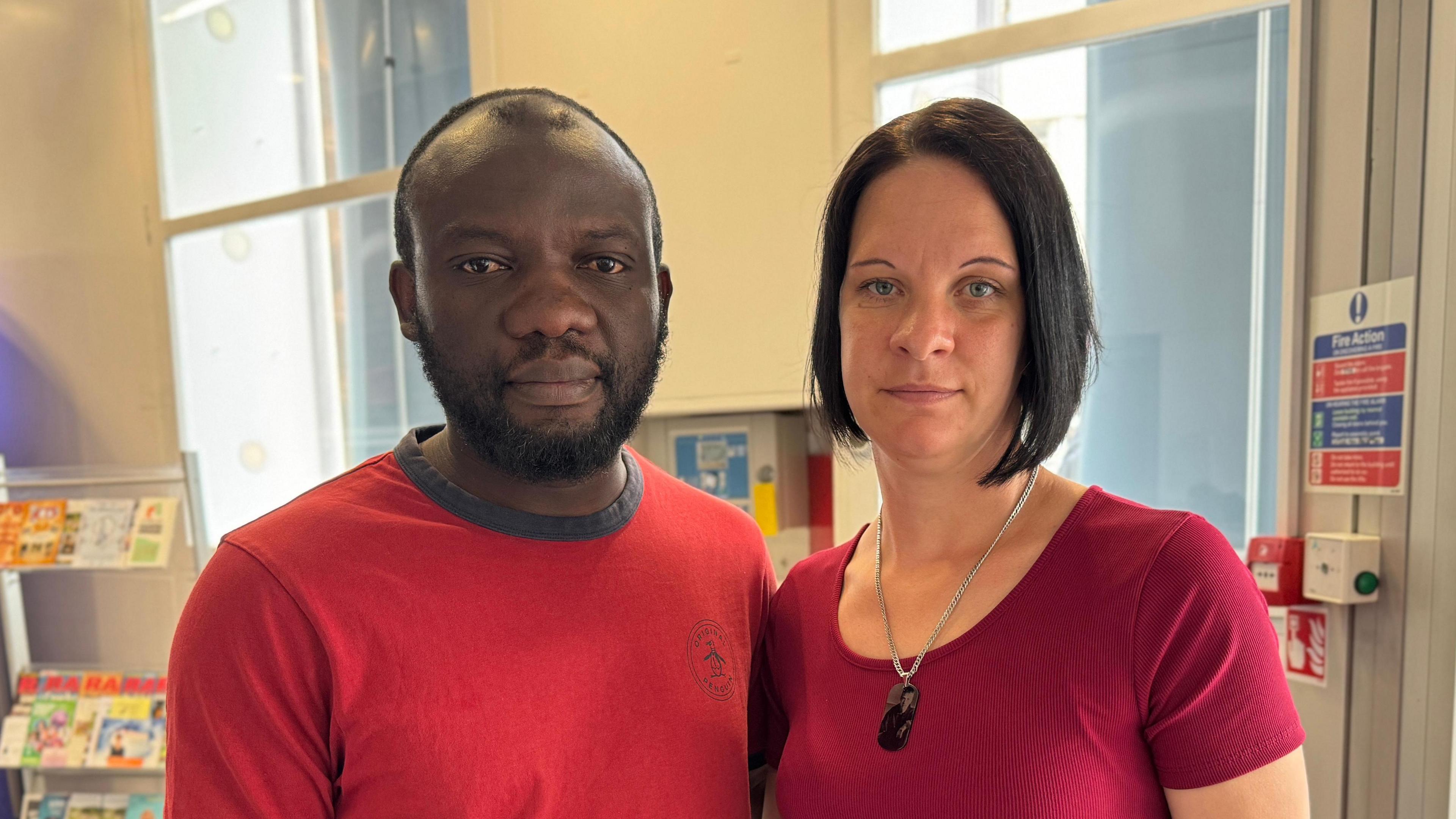 Thomas with short dark hair and beard and Laura with short dark hair, both wearing red tops