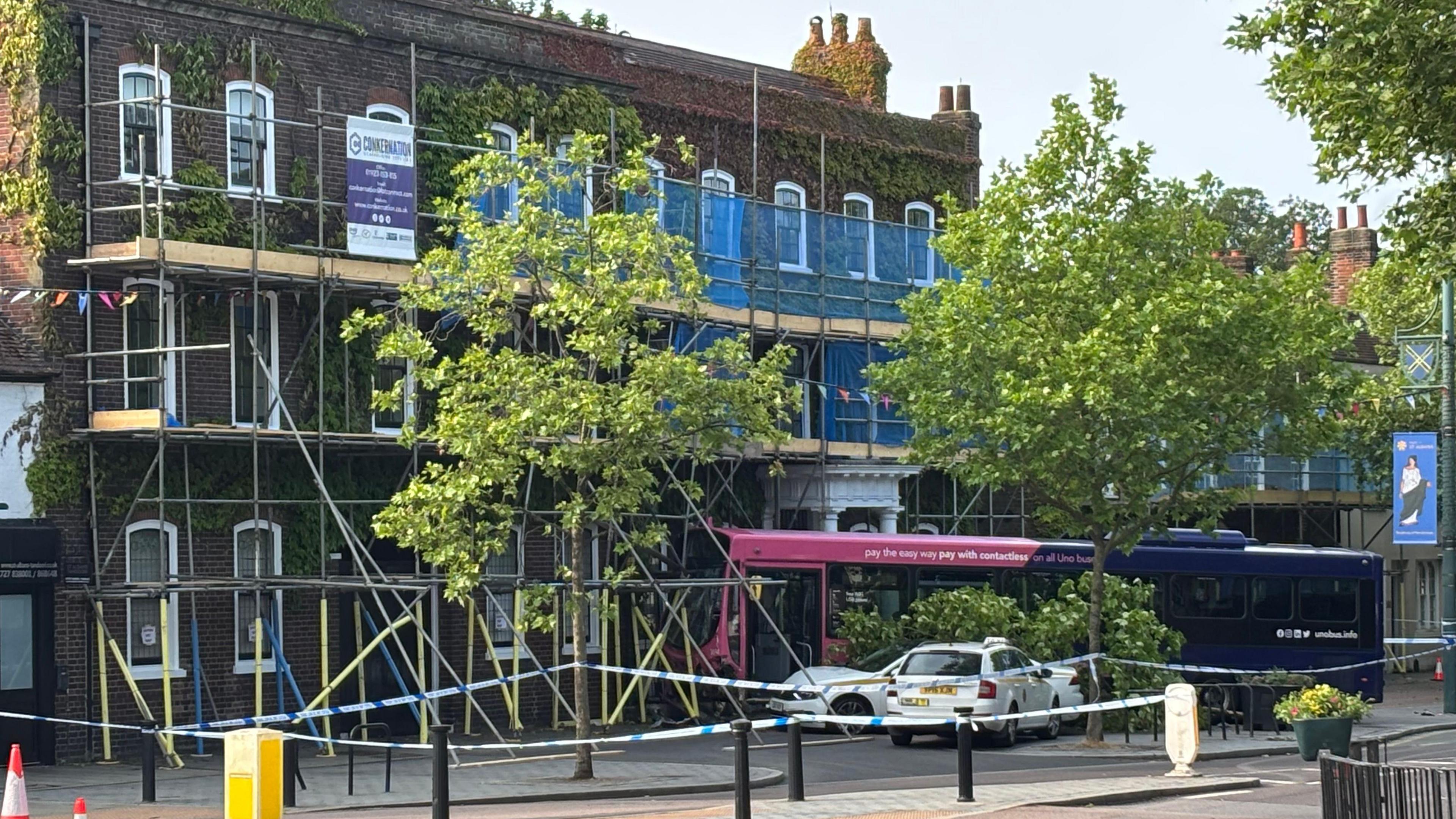 A wider view of the bus crashed into the building from a distance.