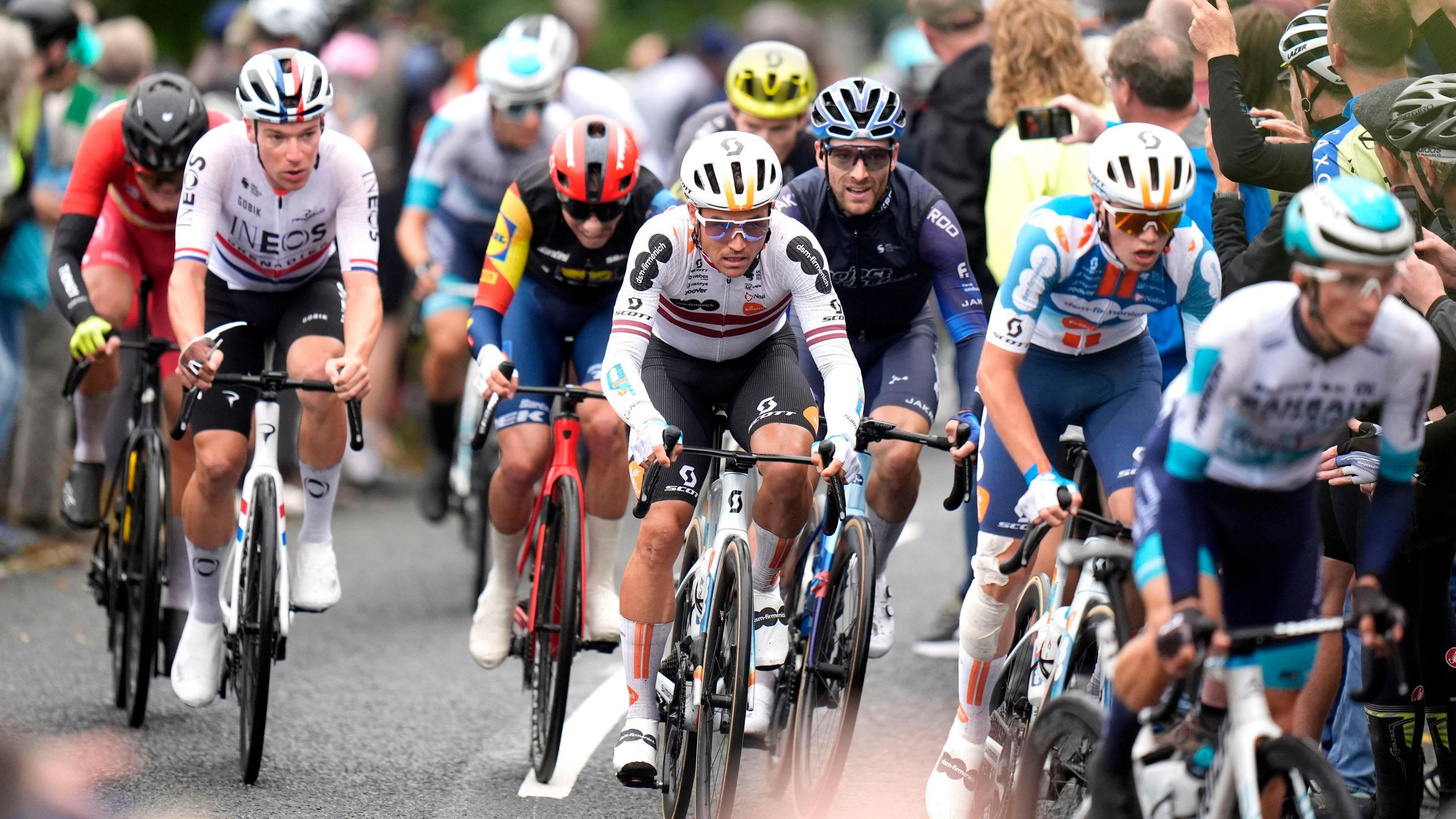 The peloton passes through a town centre on stage one of the 2024 Lloyds Bank Tour of Britain Men in Kelso in the Scottish Borders.