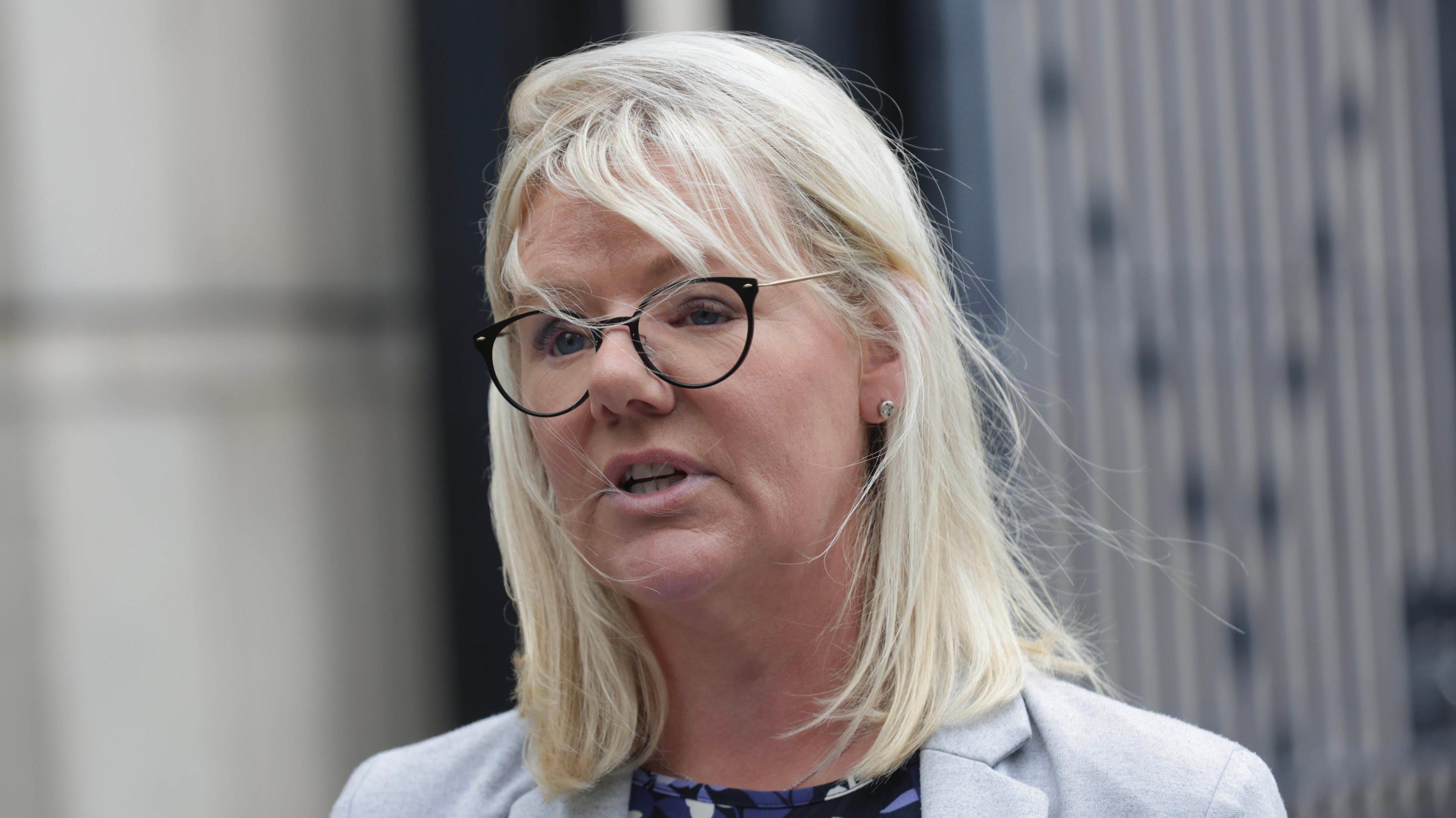 Det Sup Rachel Wilson, with shoulder length blonde hair, wearing glasses and a grey blazer.