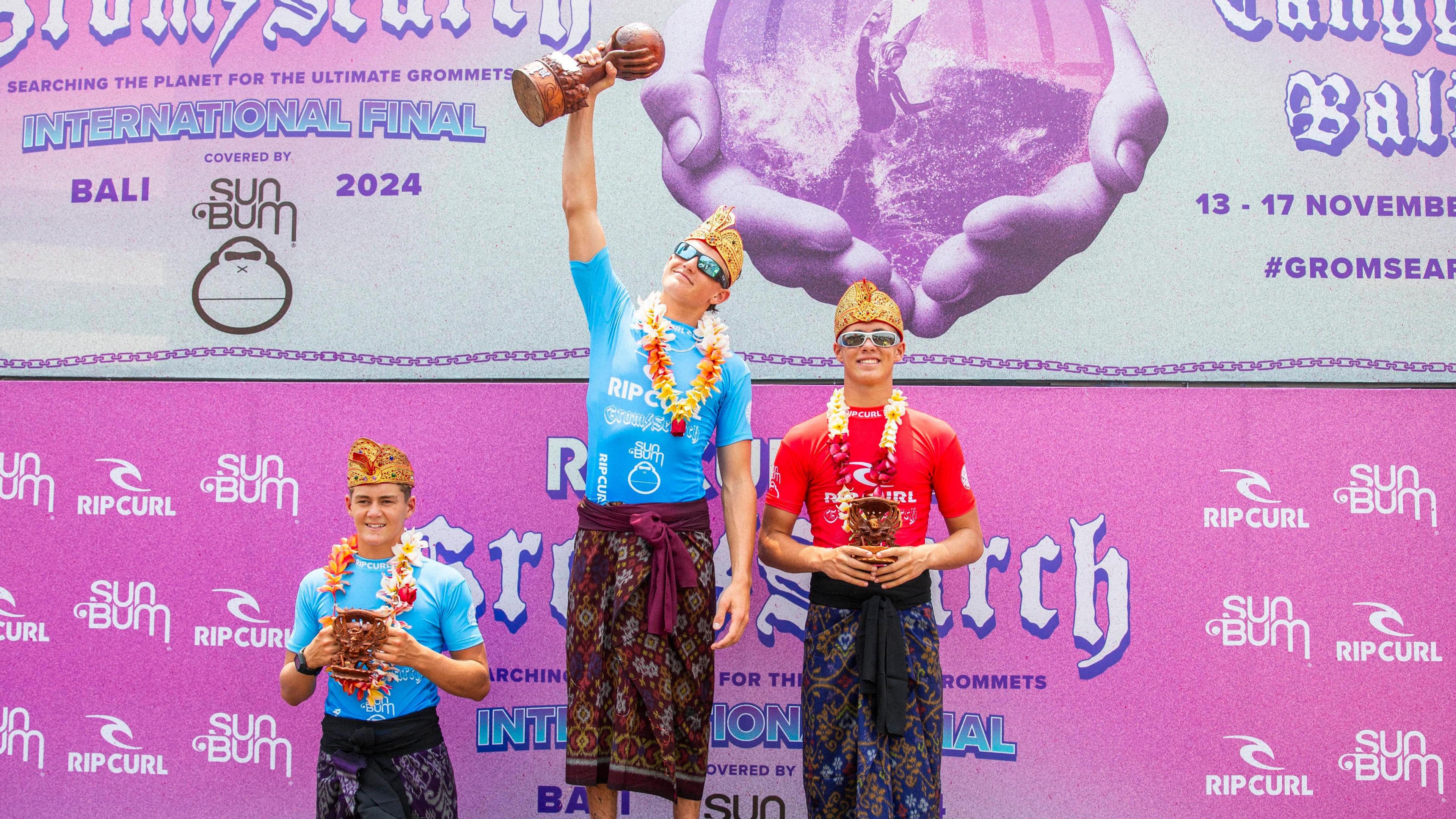 Lukas Skinner on the winners podium holding a trophy aloft