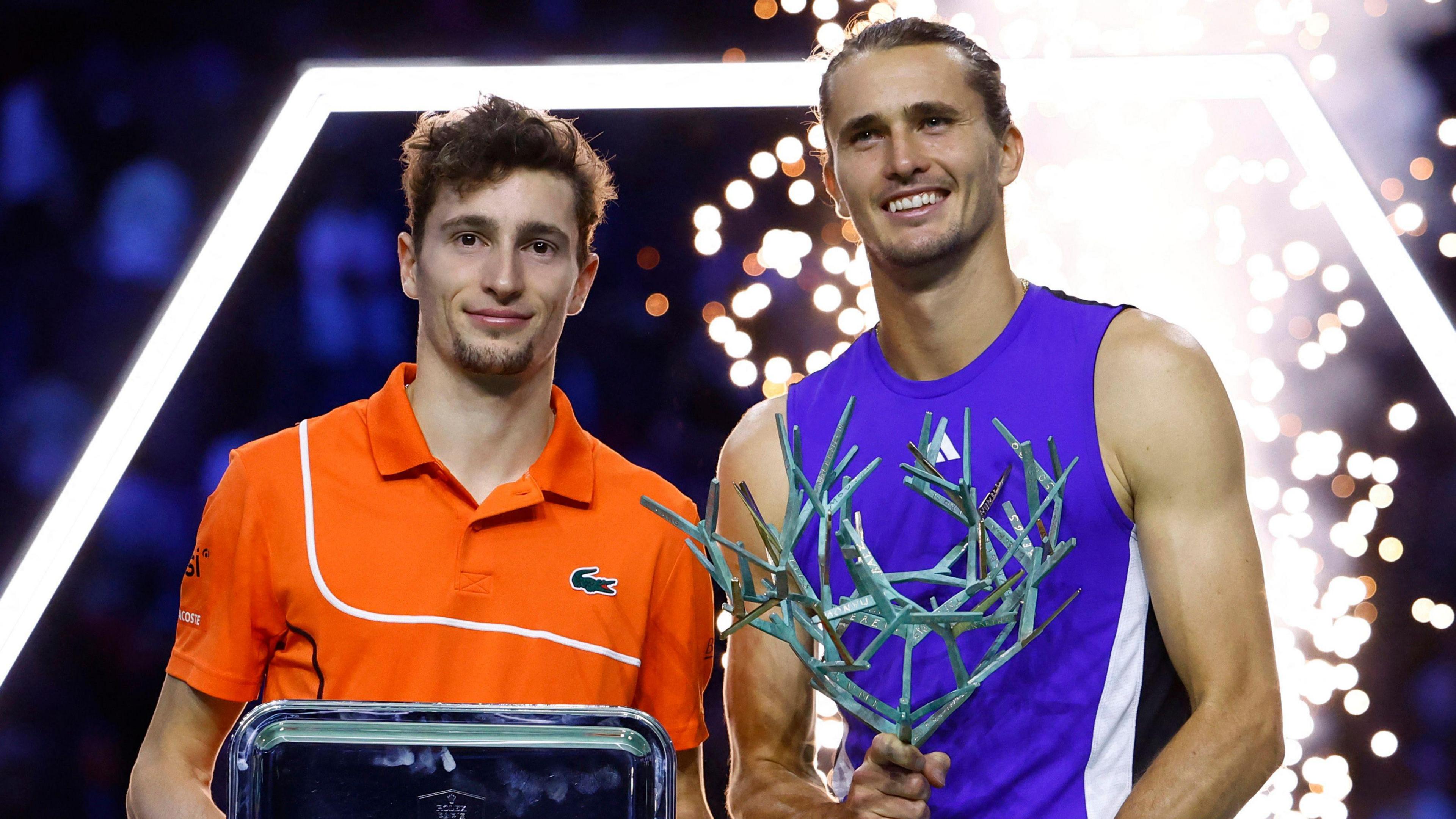 Ugo Humbert and Alexander Zverev pose with their trophies after Zverev beat Humbert in the 2024 Paris Masters final