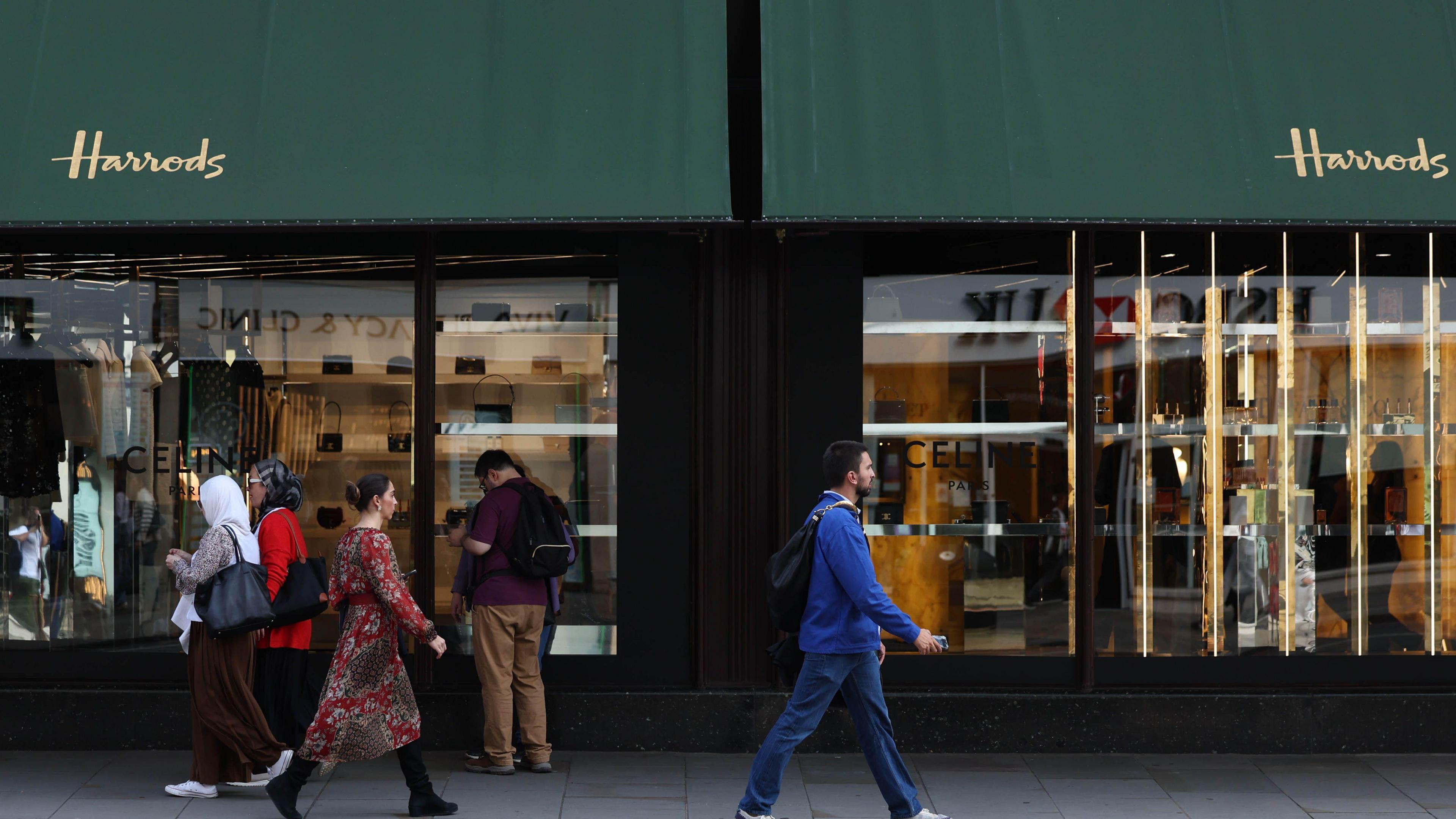 Pedestrians walk past Harrods in Knightsbridge, London