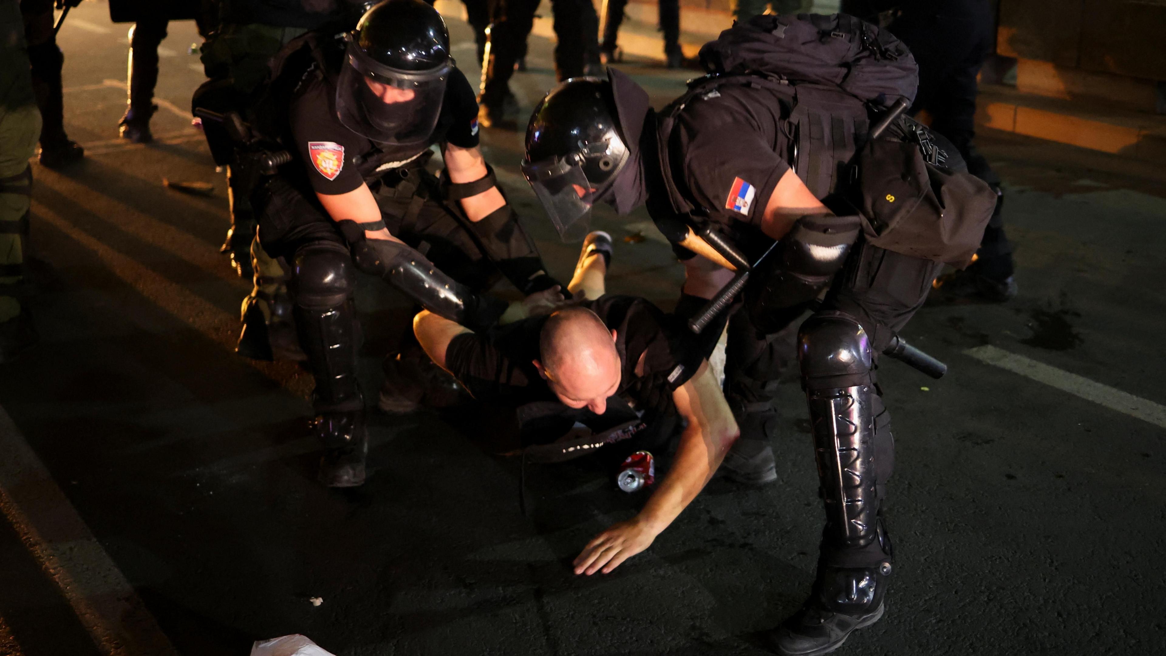 Law enforcement officers detain a demonstrator, during an anti-government protest demanding snap elections, in Belgrade